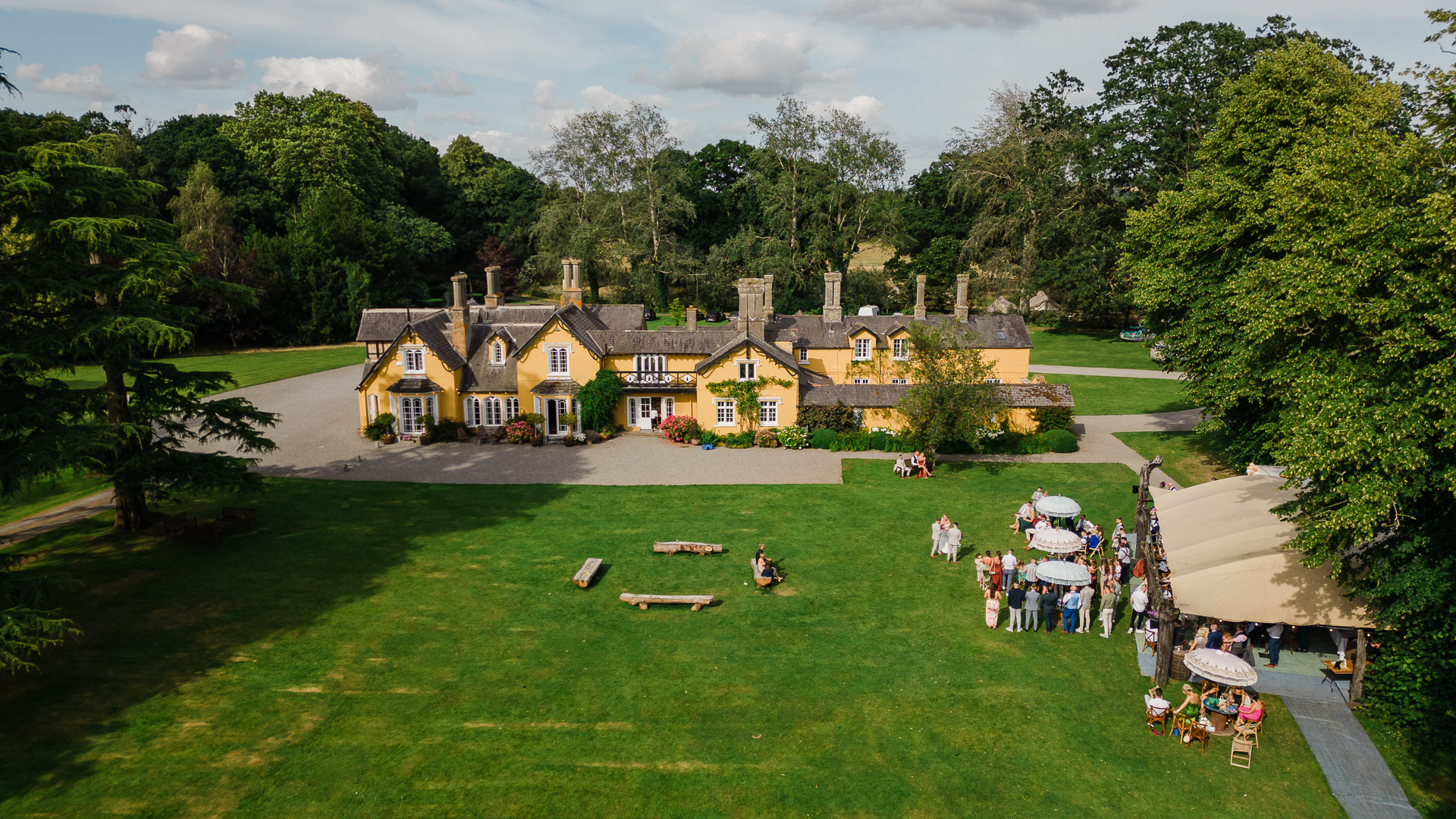 A large house with a lawn and trees in front of it