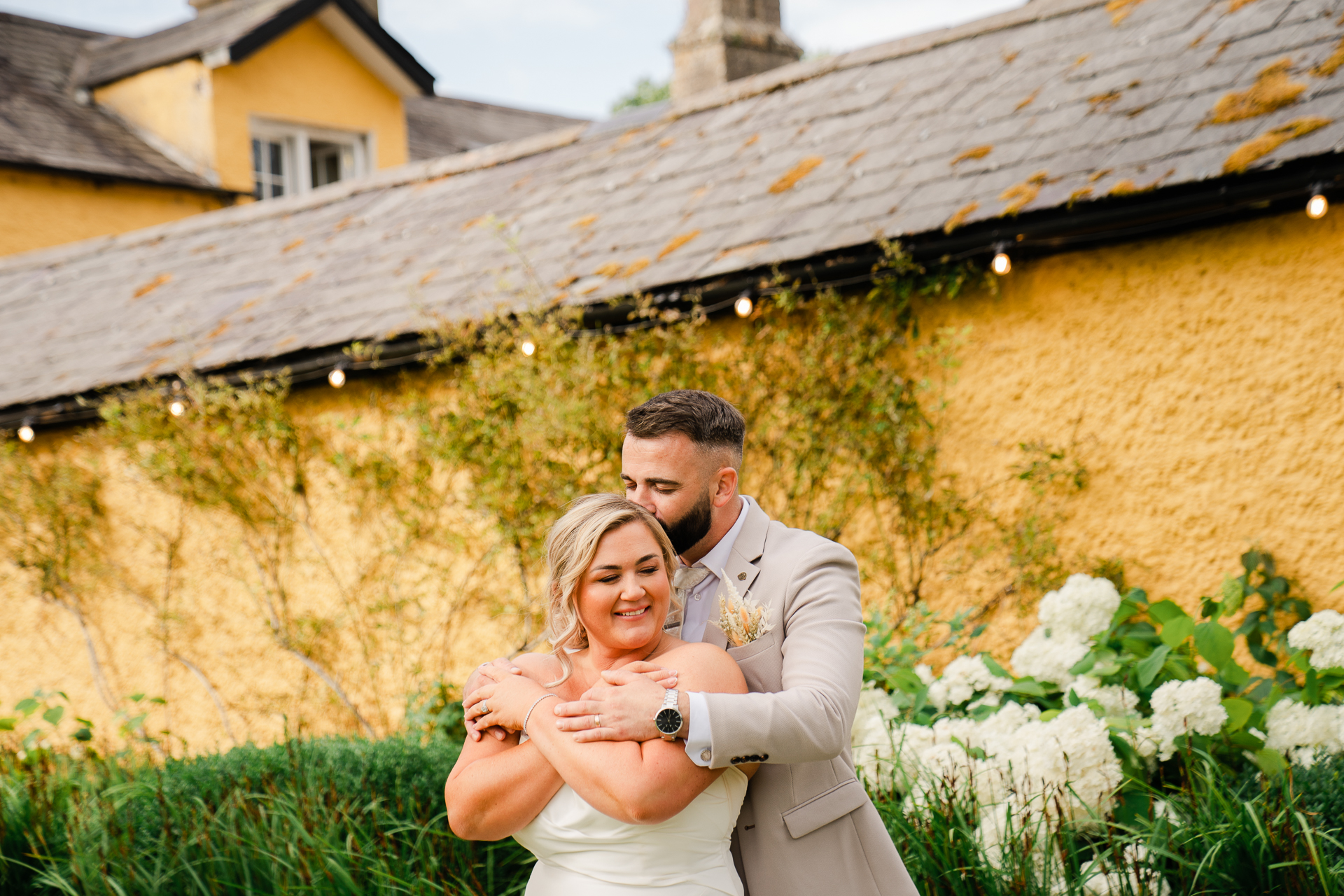 A man and woman posing for a picture in front of a house