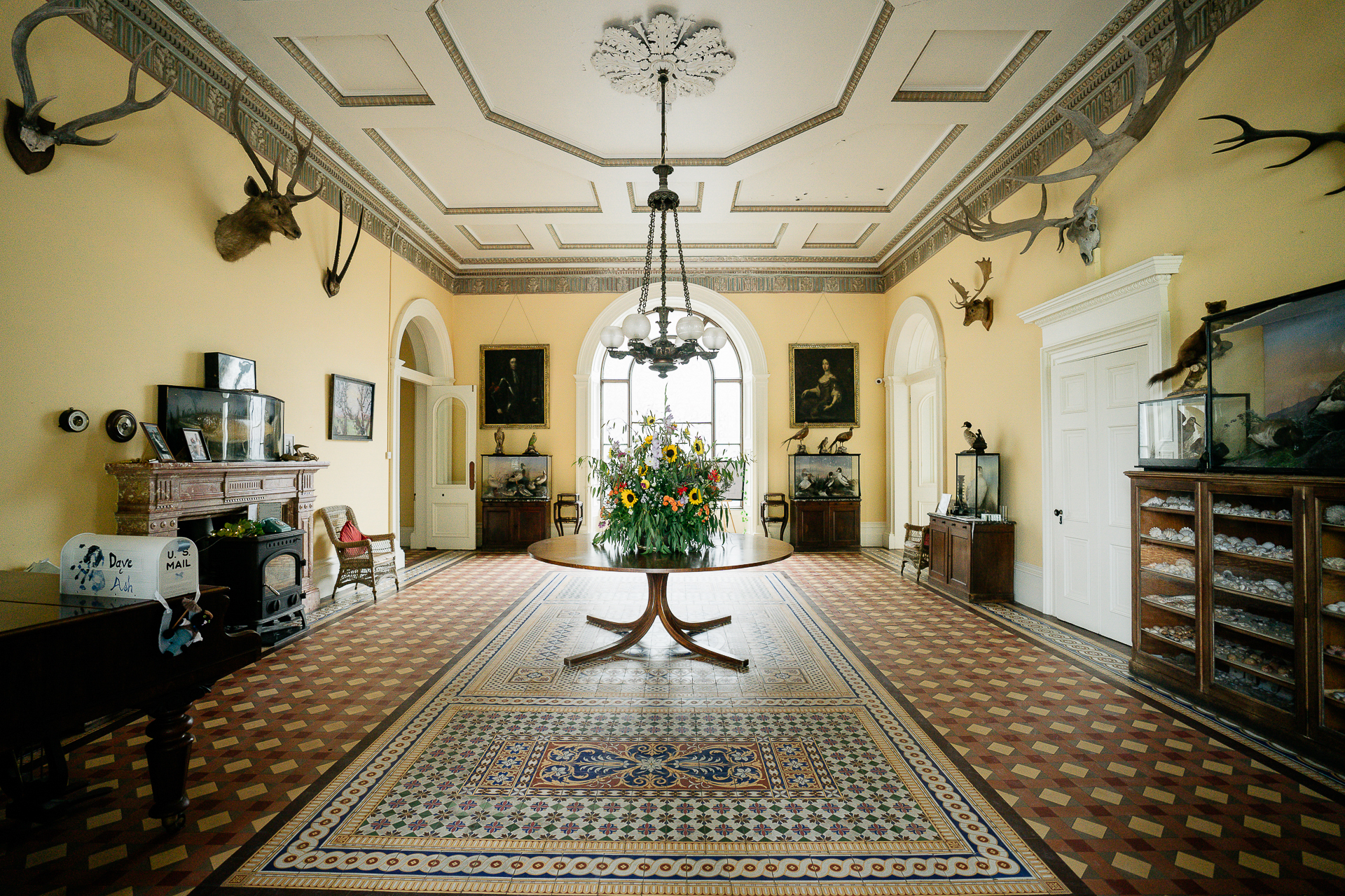 A large room with a chandelier and a table with flowers