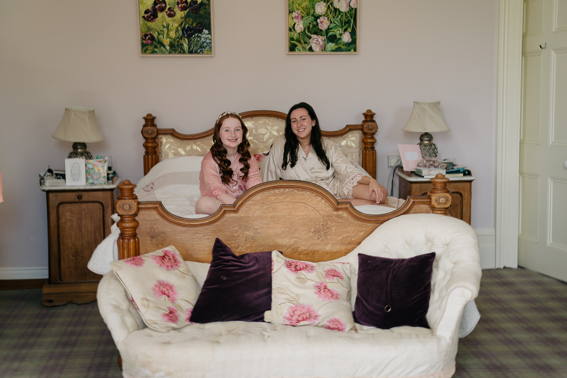 Two women sitting on a bed