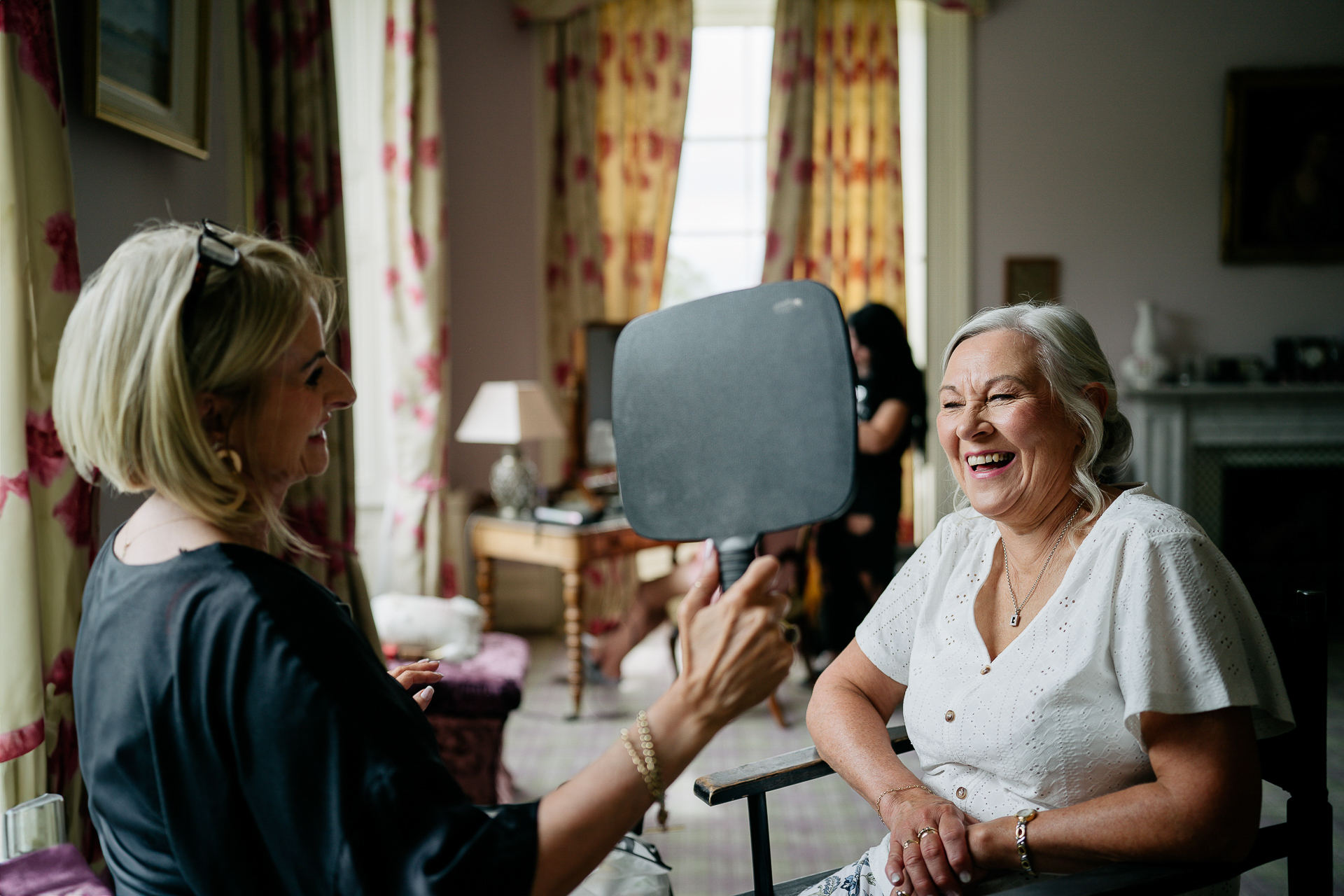 A person sitting next to an older woman in a chair