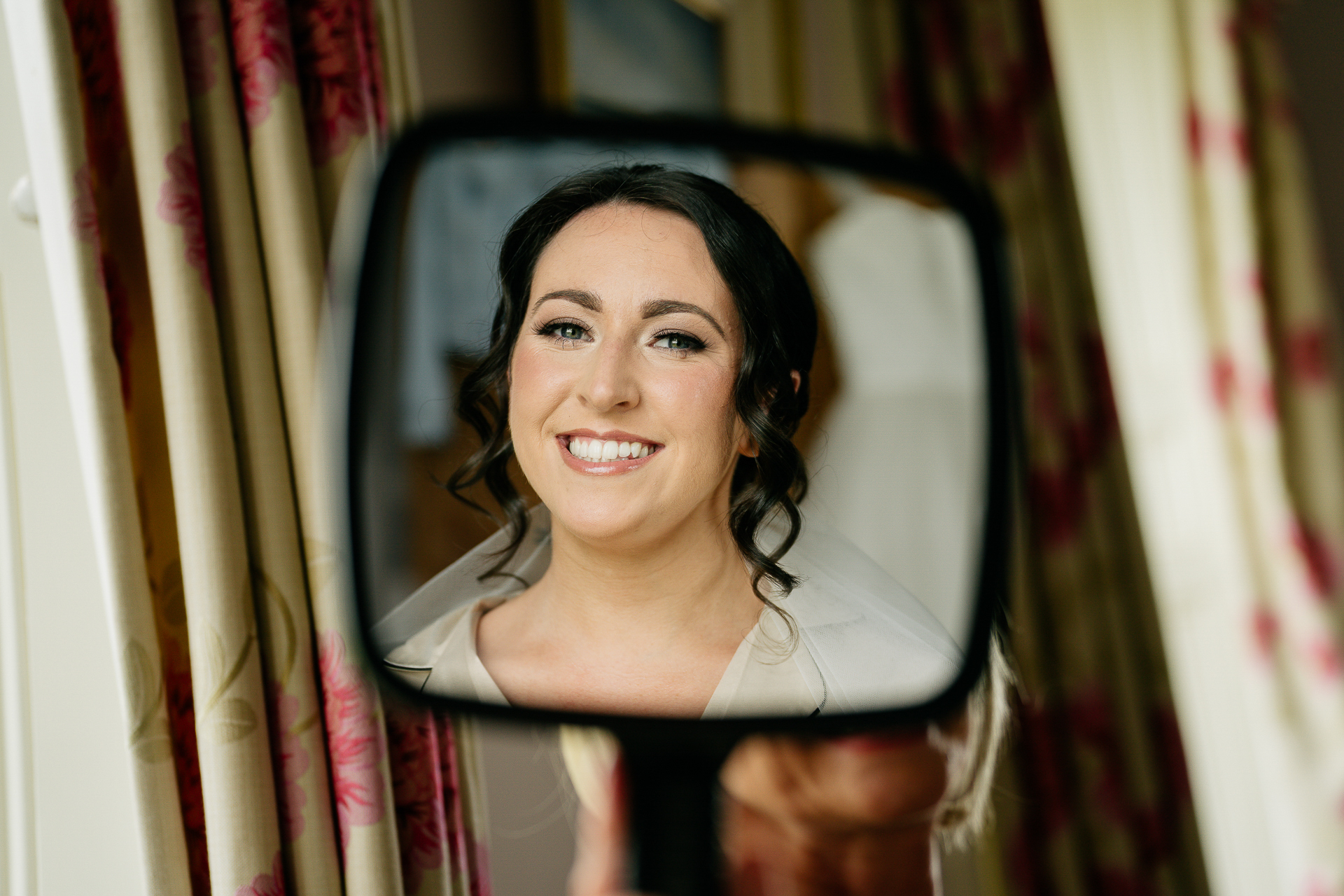 A woman smiling and looking through a window