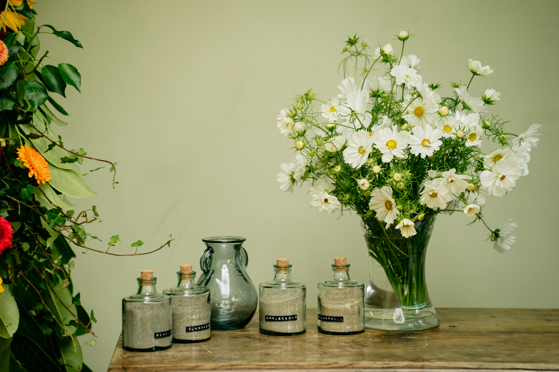 A vase of flowers and jars on a table