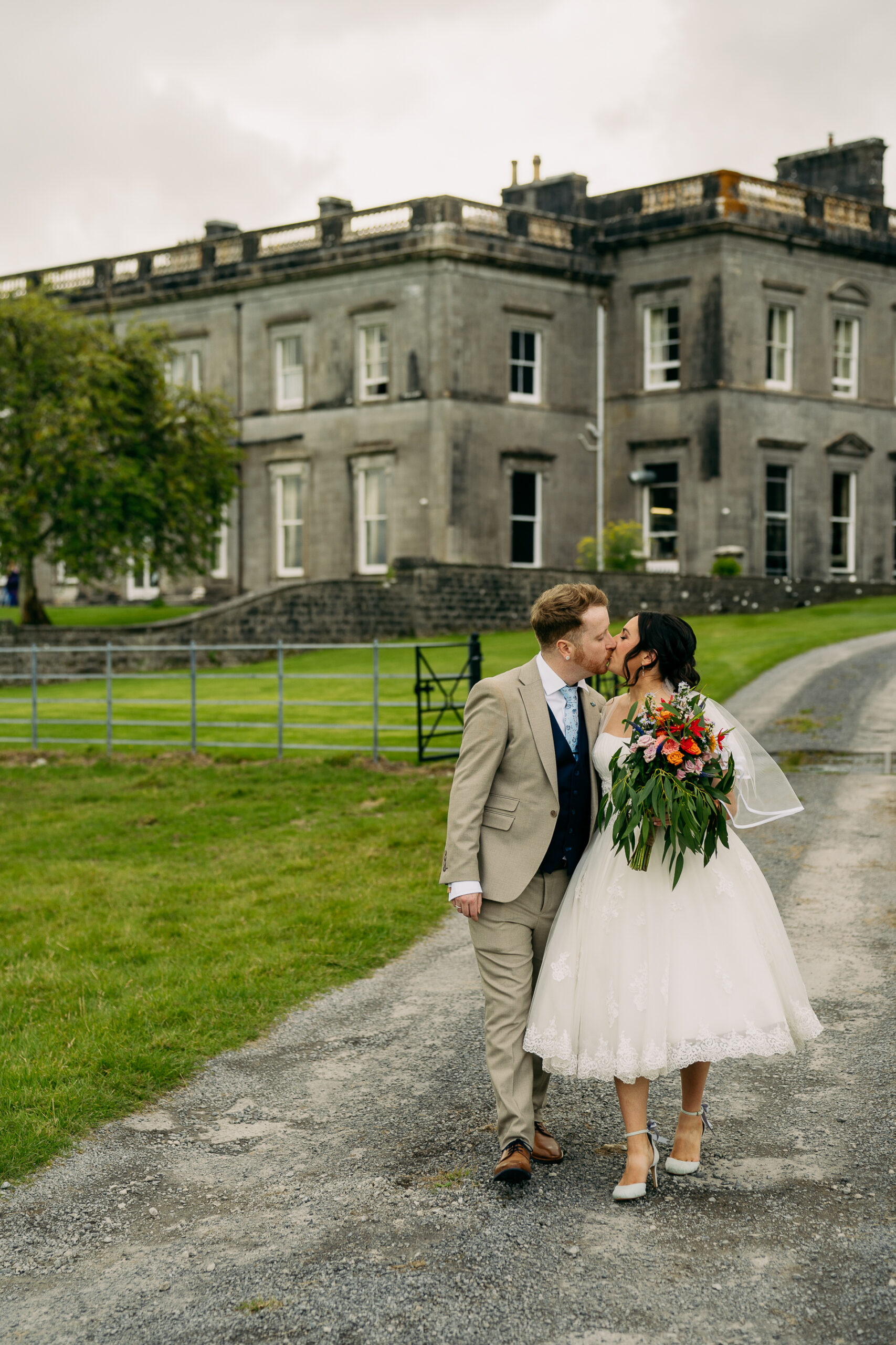 A man and woman kissing in front of a building