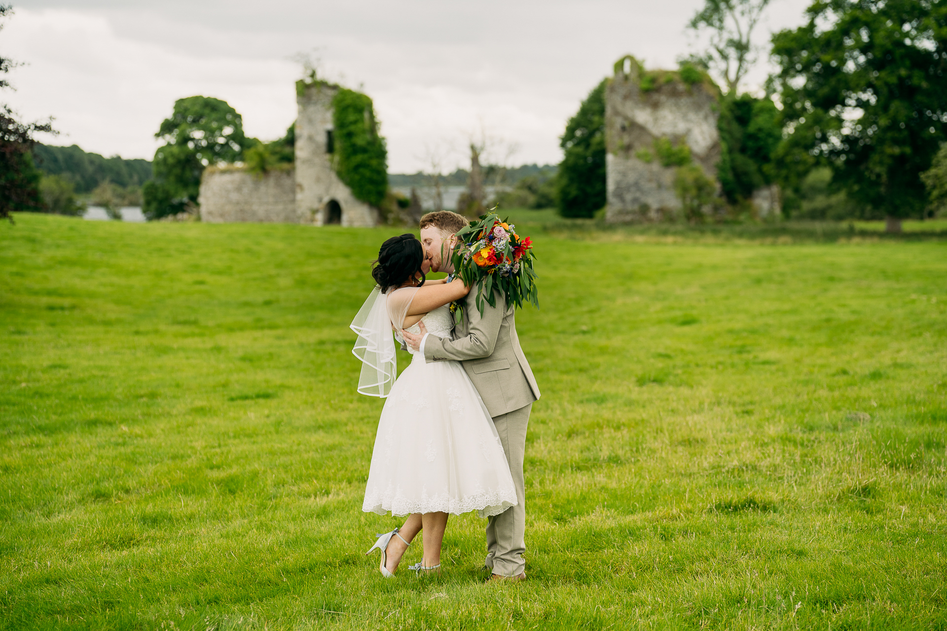 A person and a child kissing in a grassy field