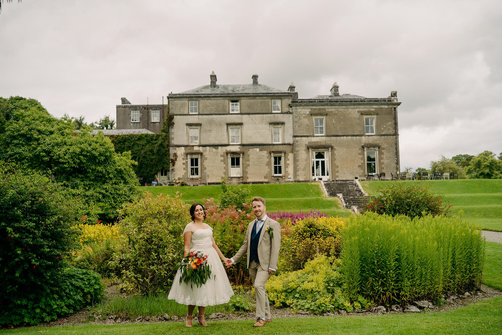 A man and woman posing in front of a large building