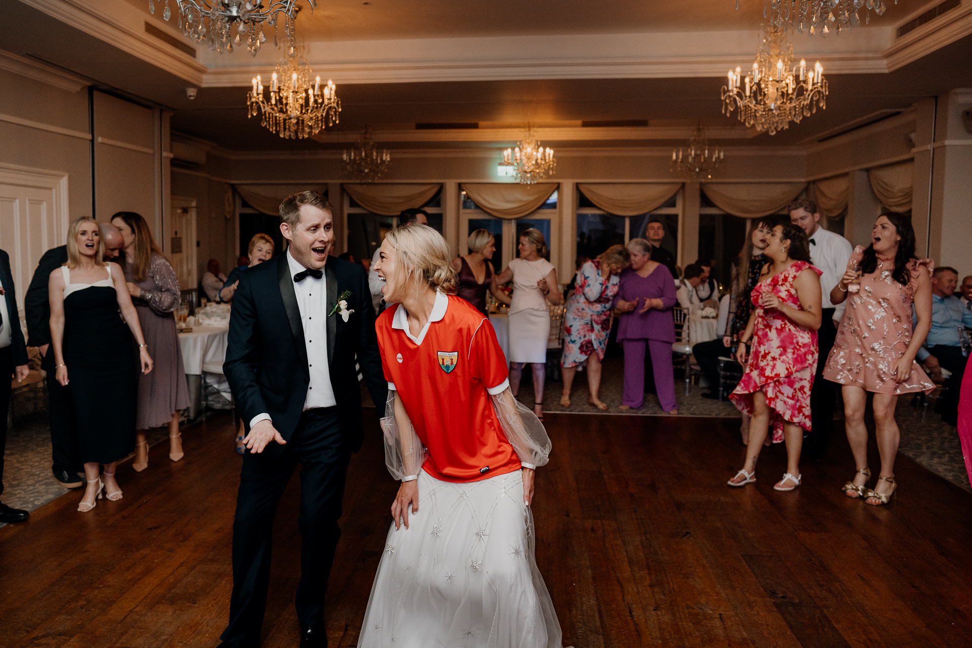 A man and woman dancing in a room full of people