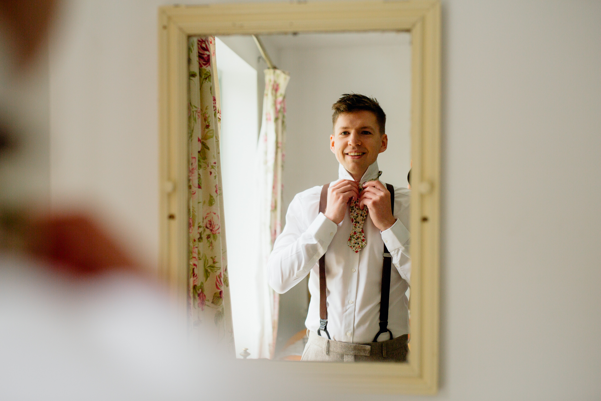 A man in a tie and a white shirt is smiling