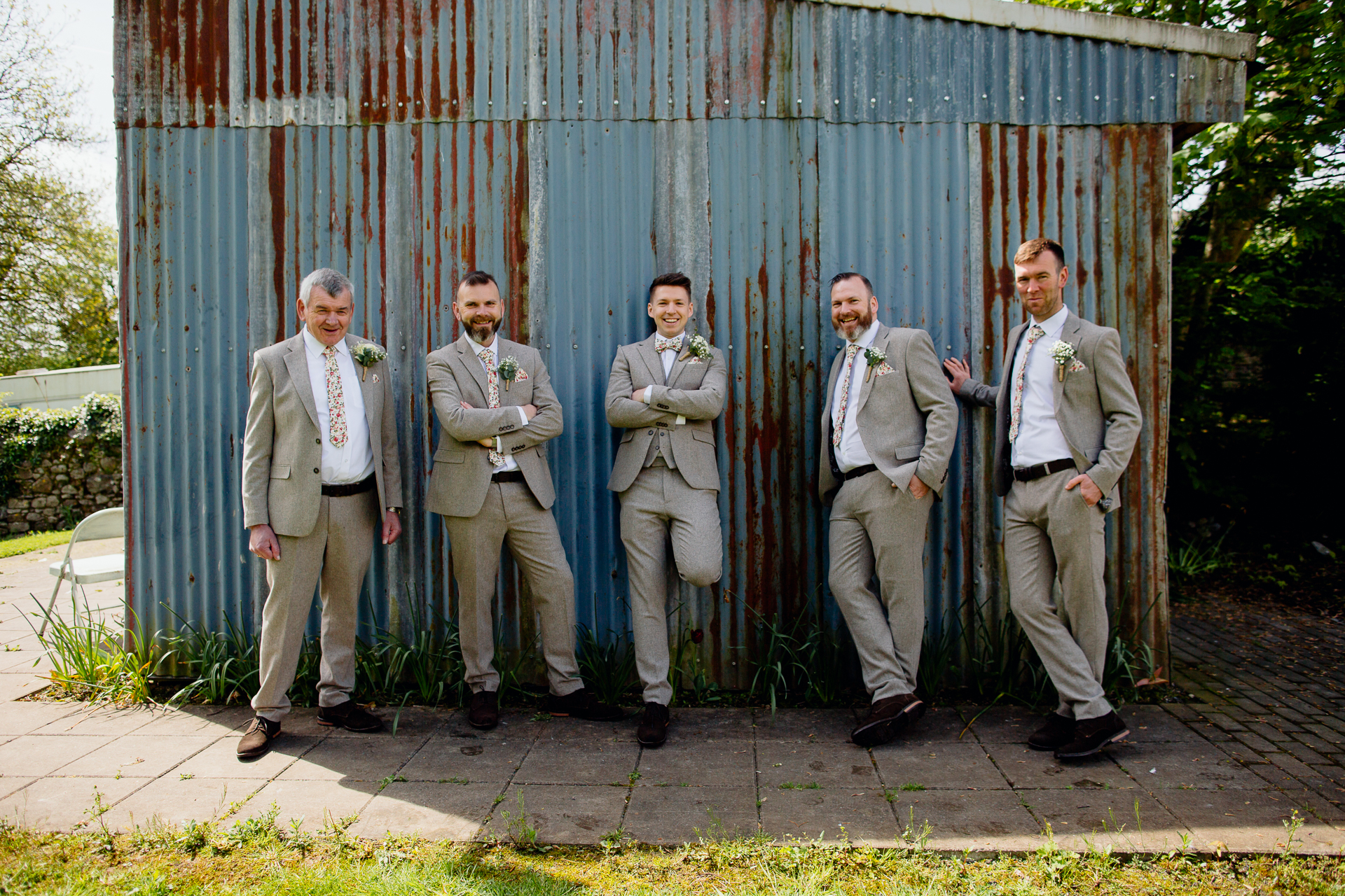 A group of men in suits standing in front of a fence