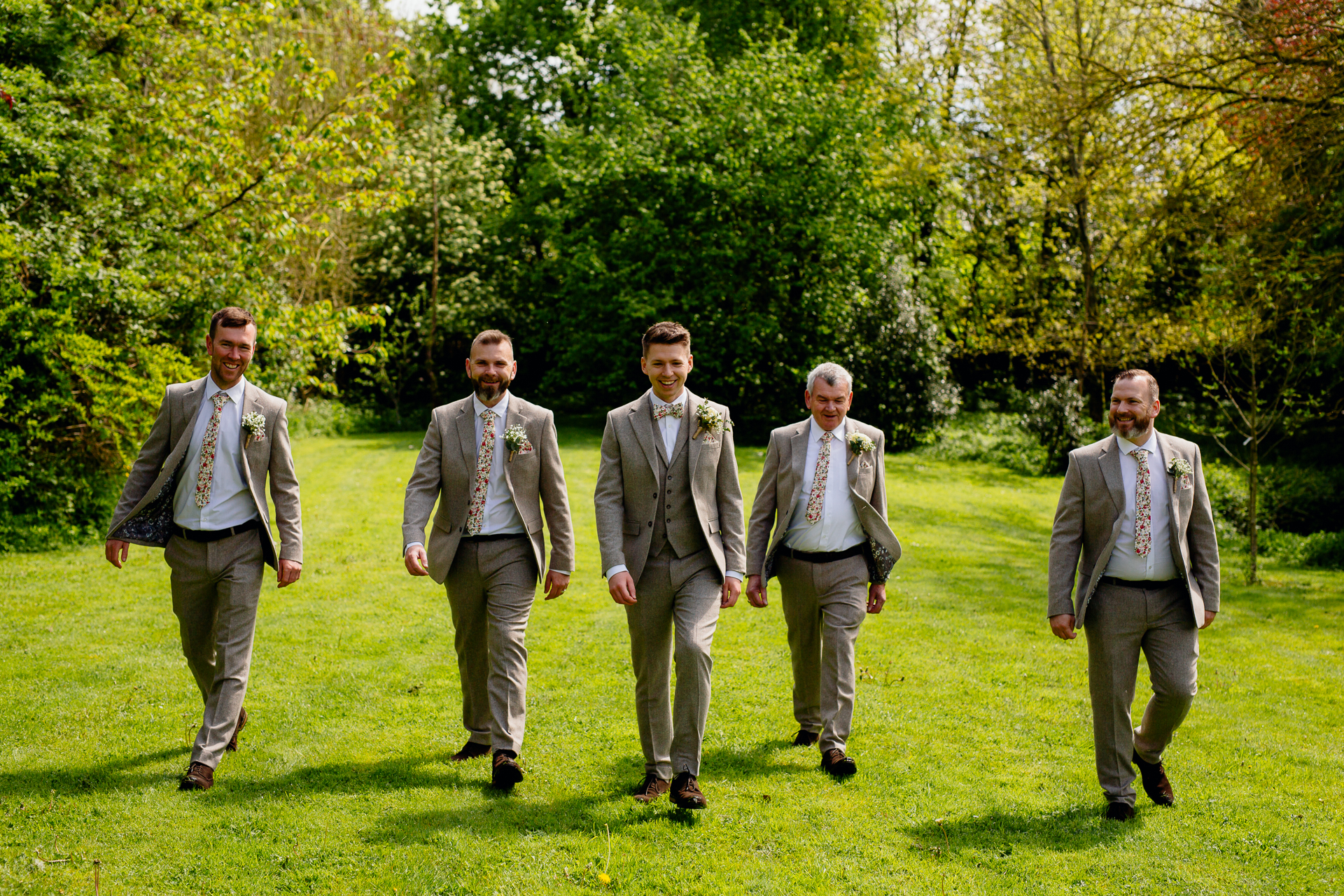 A group of men walking on a grass field