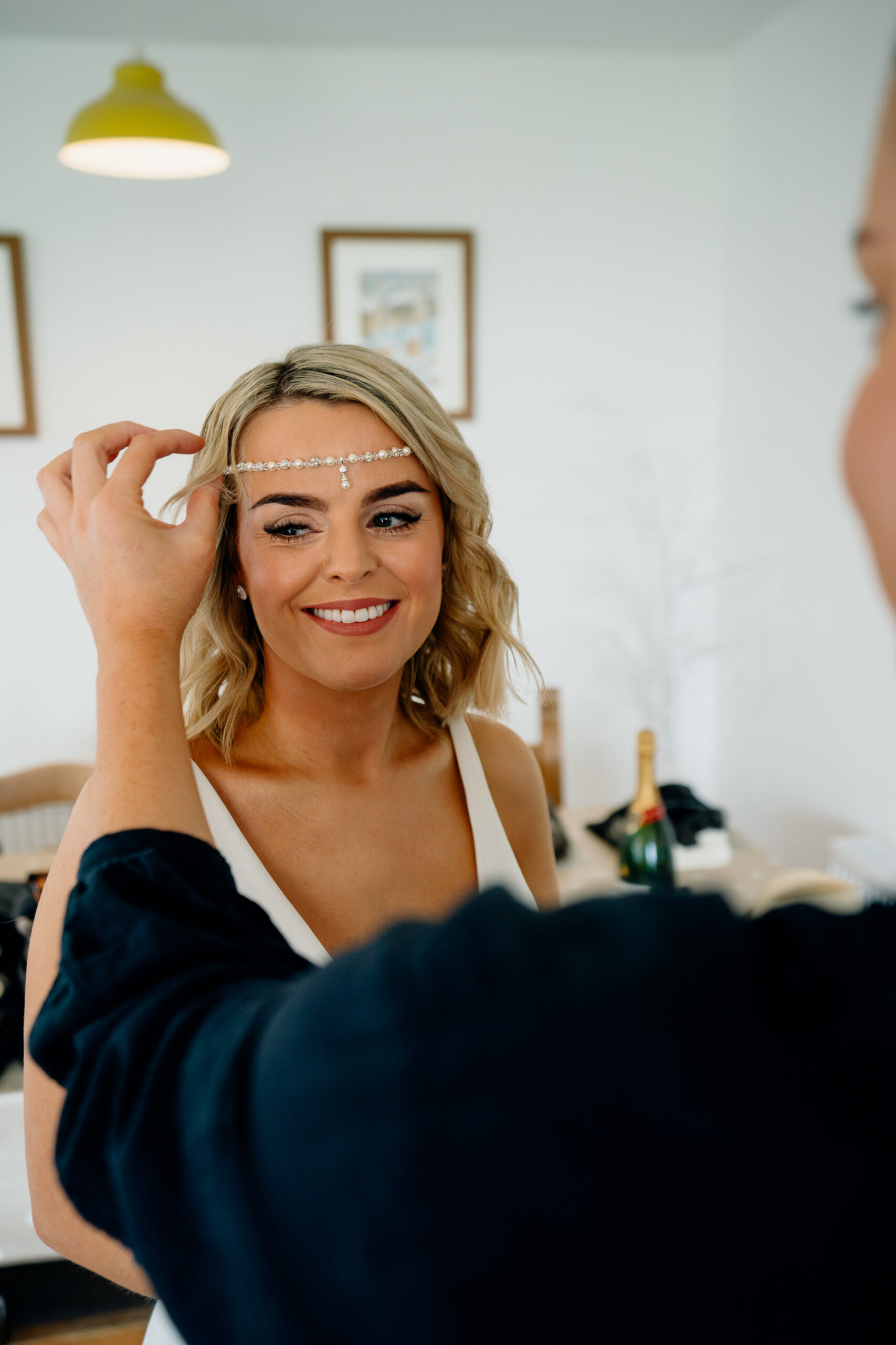 A woman smiling and holding her hair up