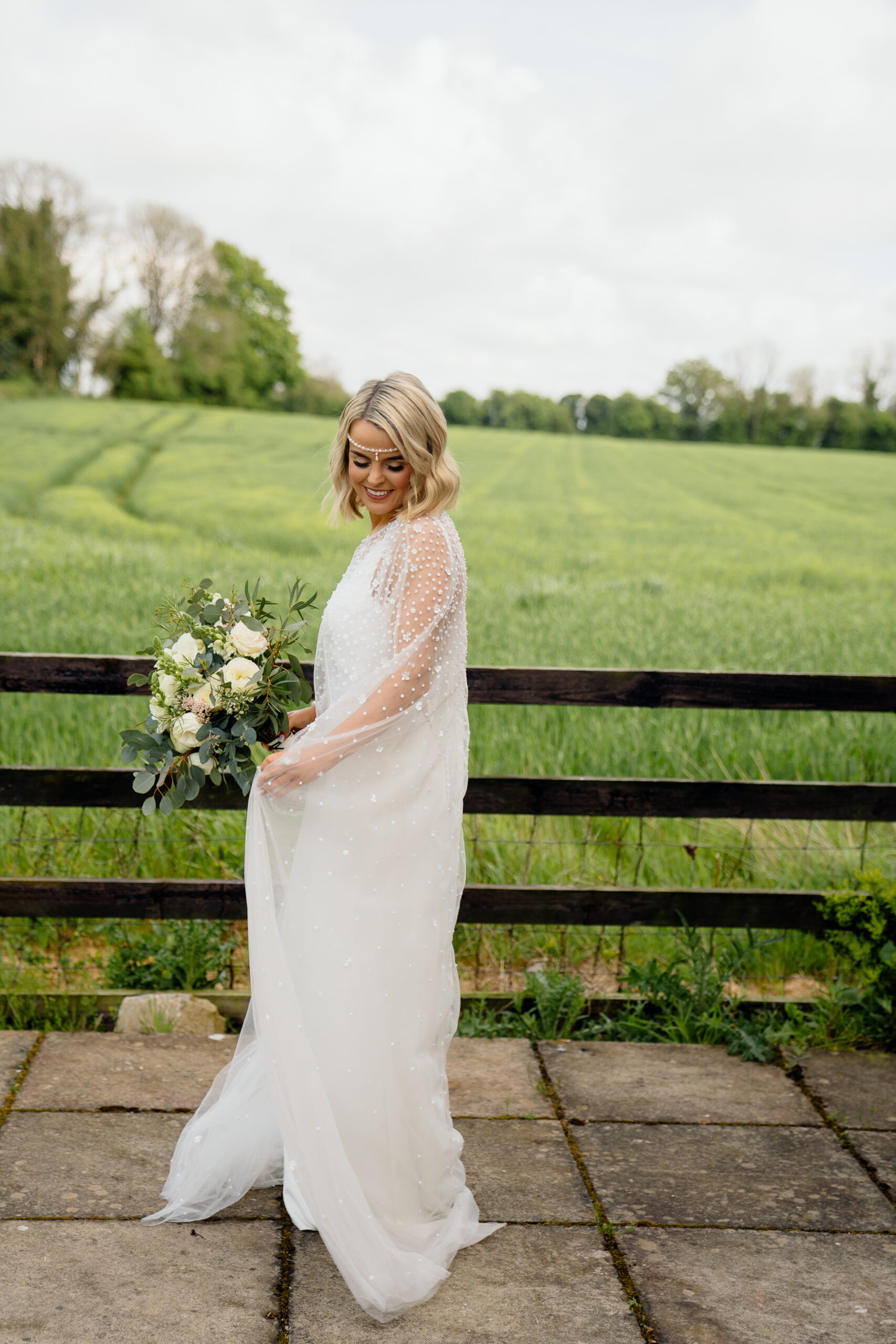 A person in a white dress holding flowers