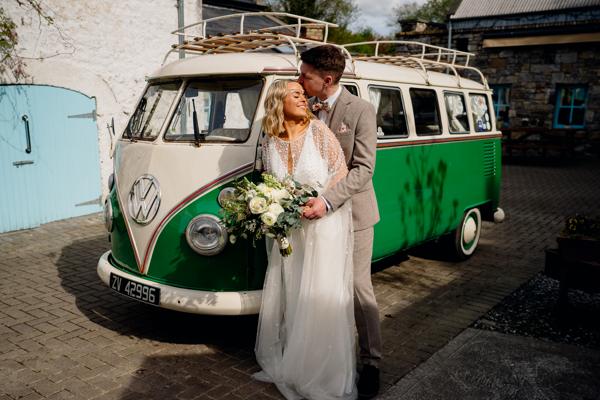 A man and woman in front of a van with flowers