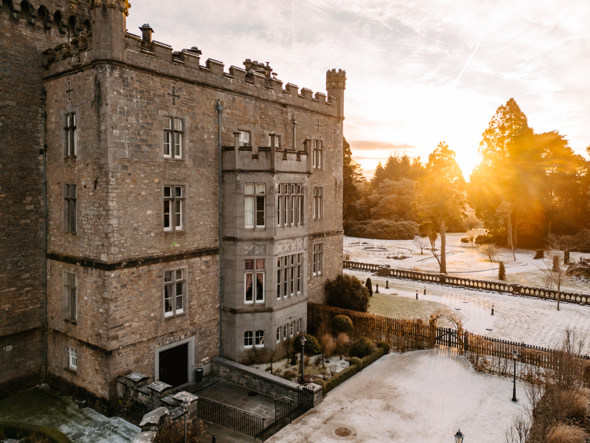 A stone building with a snowy yard