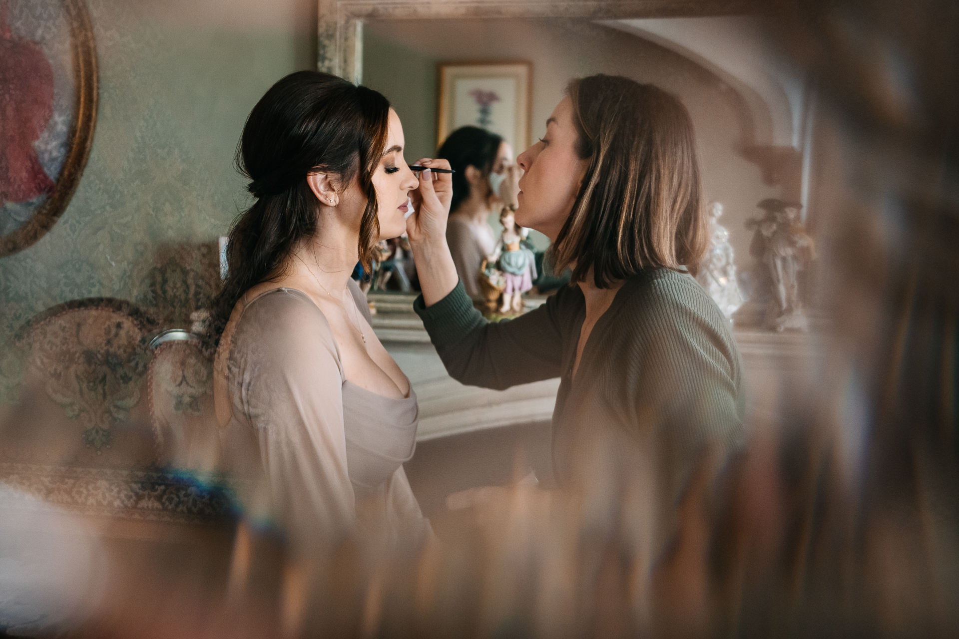 A person taking a picture of another woman in a mirror