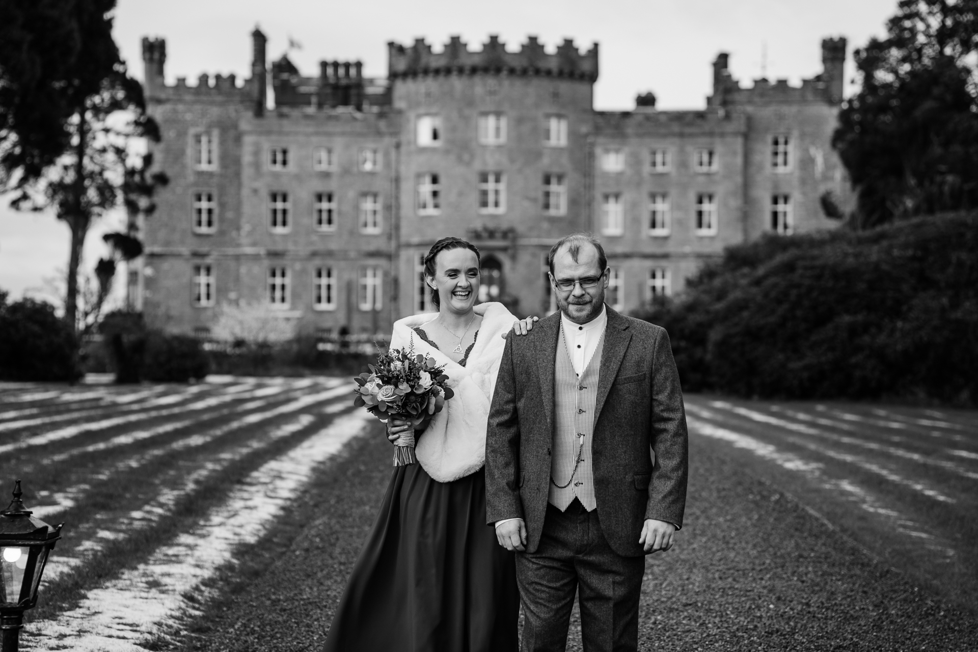 A man and woman posing for a picture in front of a large building