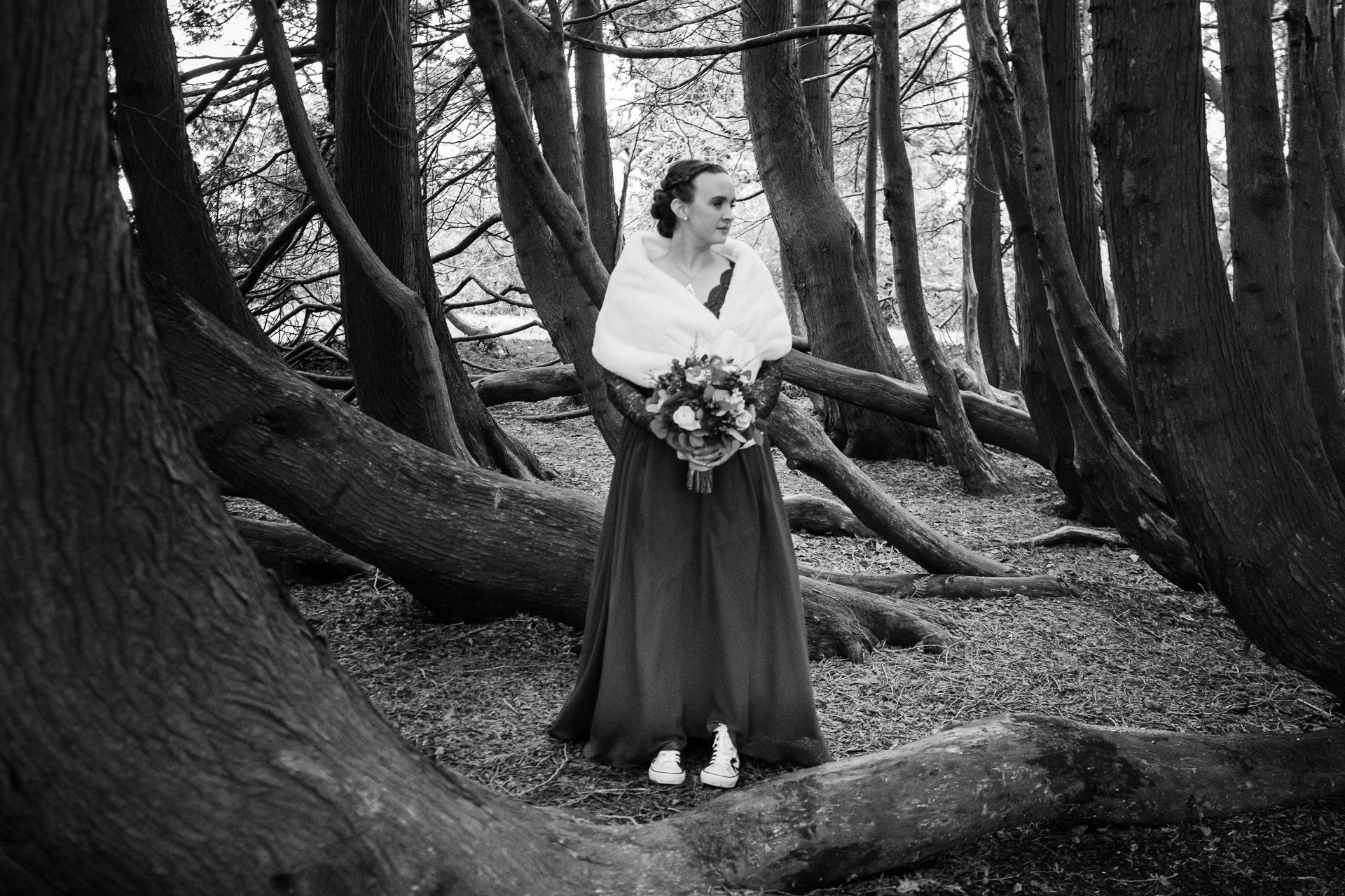 A person in a wedding dress standing in a forest