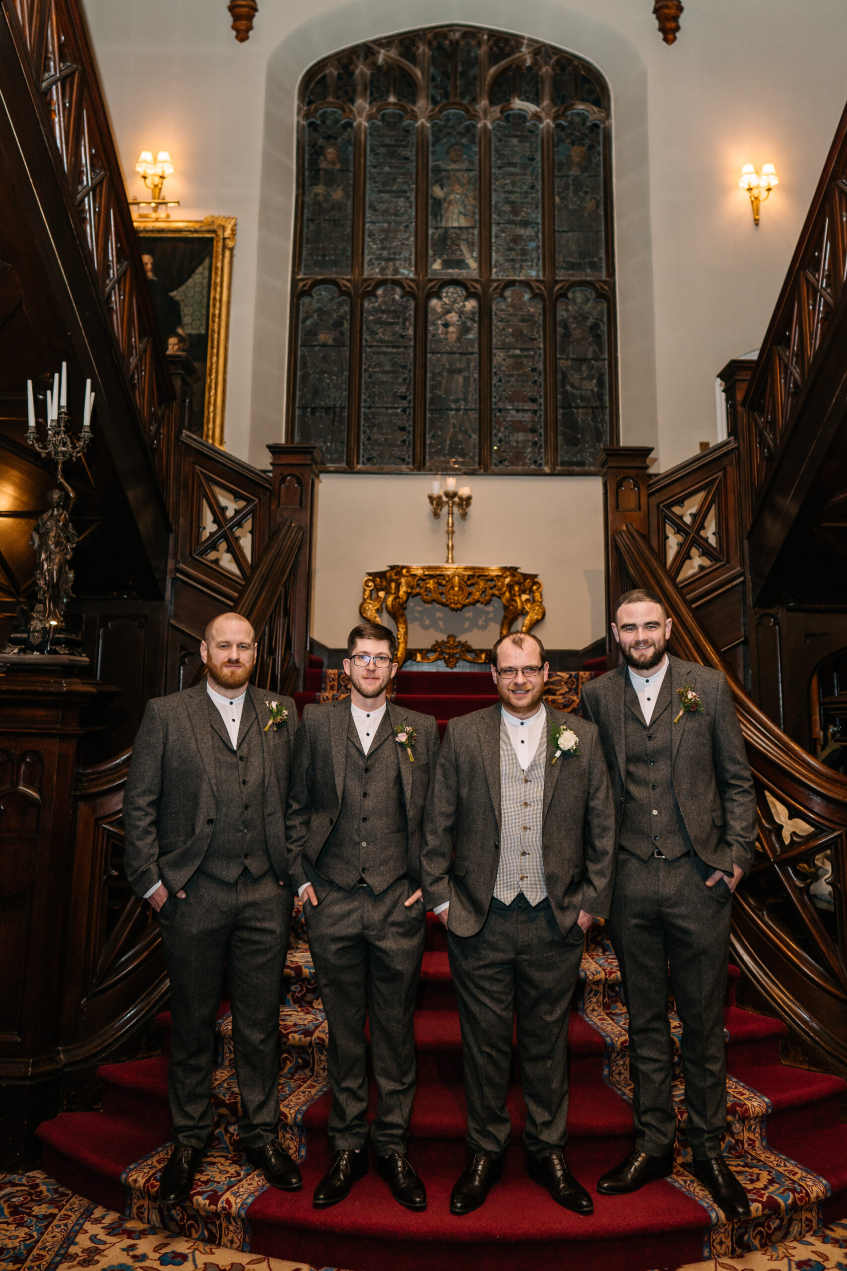 A group of men posing for a photo in front of a large ornate staircase