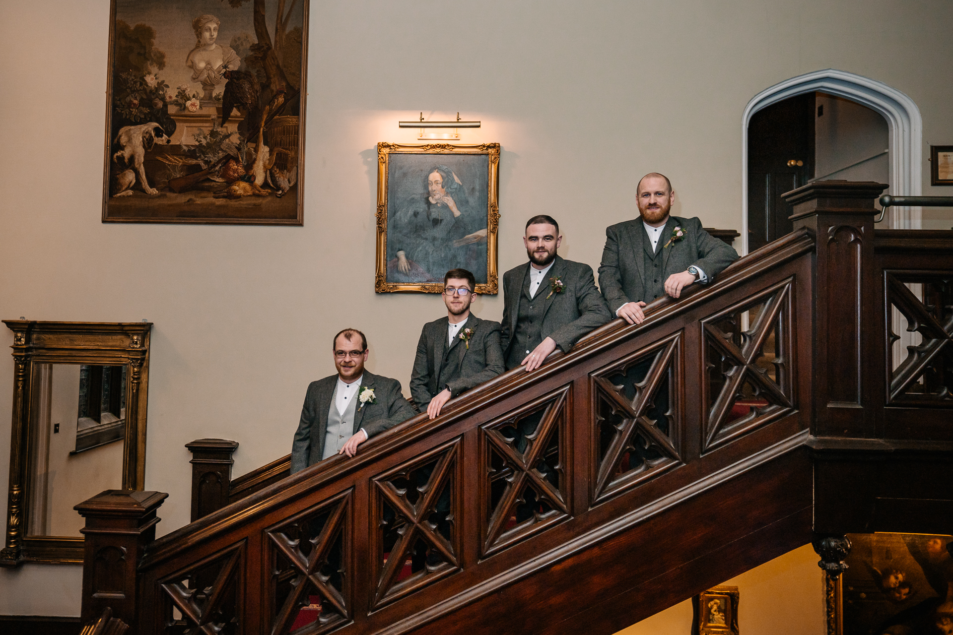 A group of men in suits standing on a wooden staircase