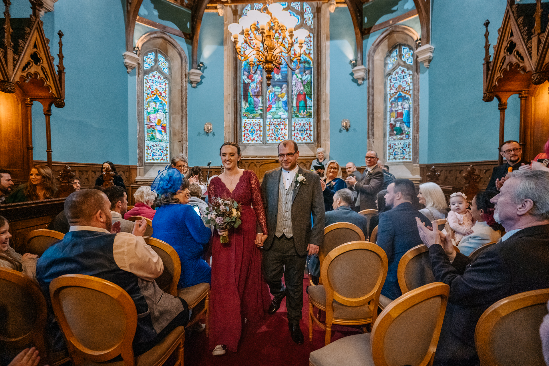 A man and woman walking down a aisle in a church