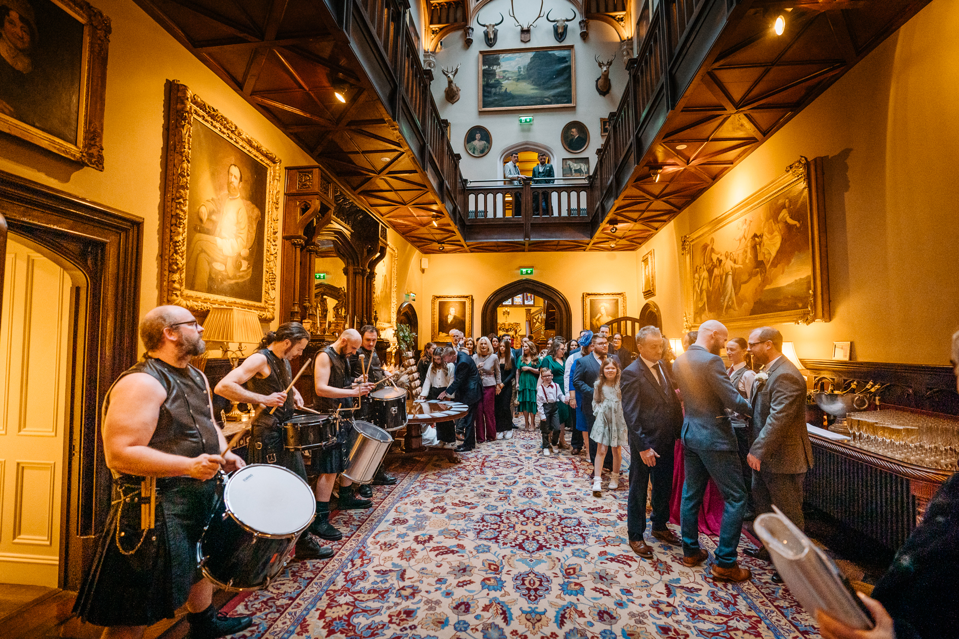 A group of people playing instruments in a room with a crowd of people