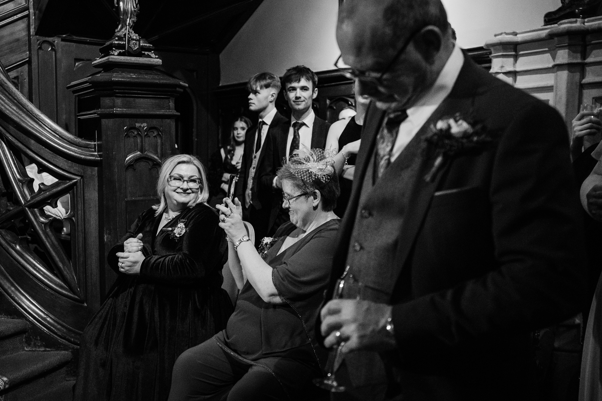 A person in a suit and tie holding a glass of wine