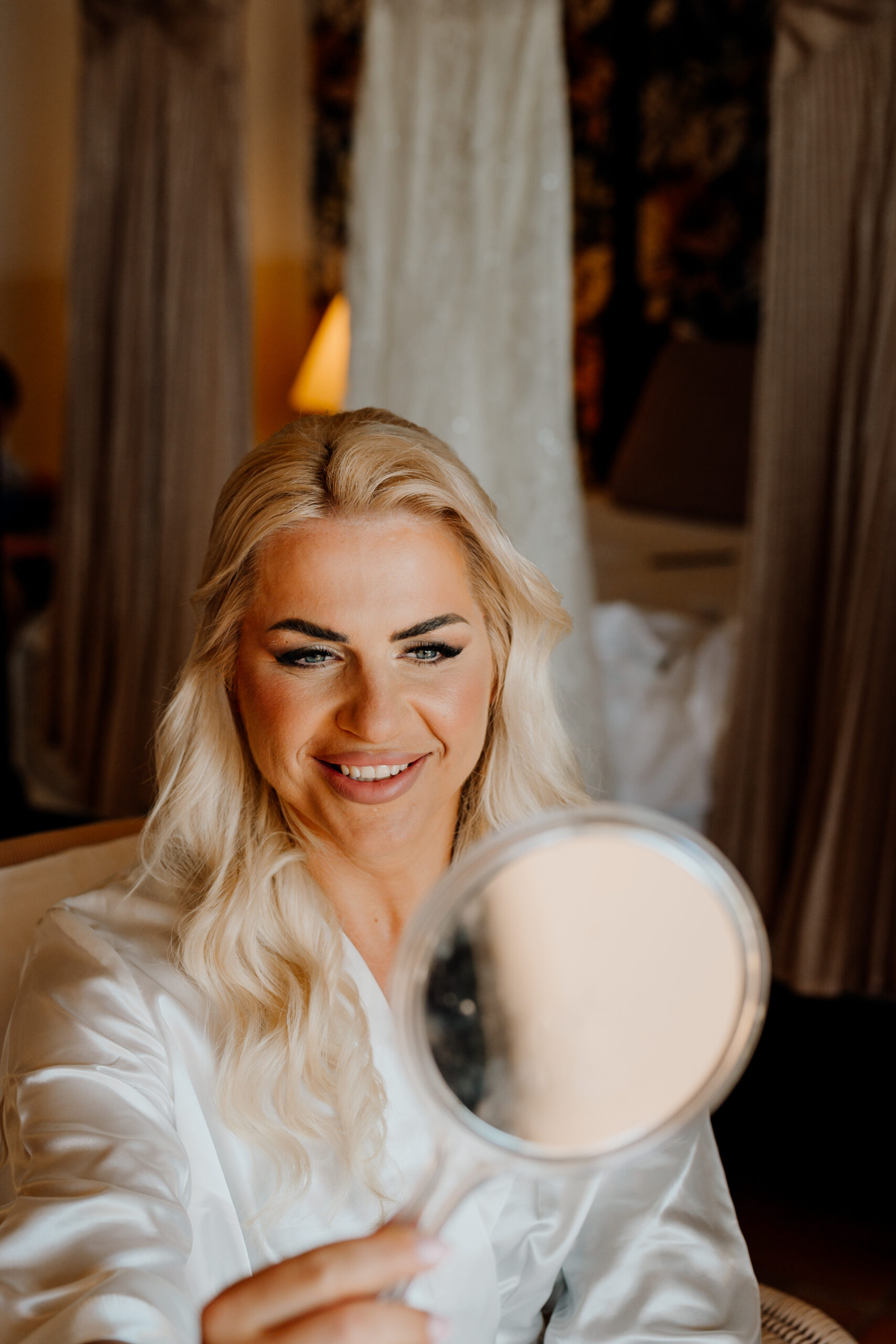 A woman with a white wig and white dress holding a white object