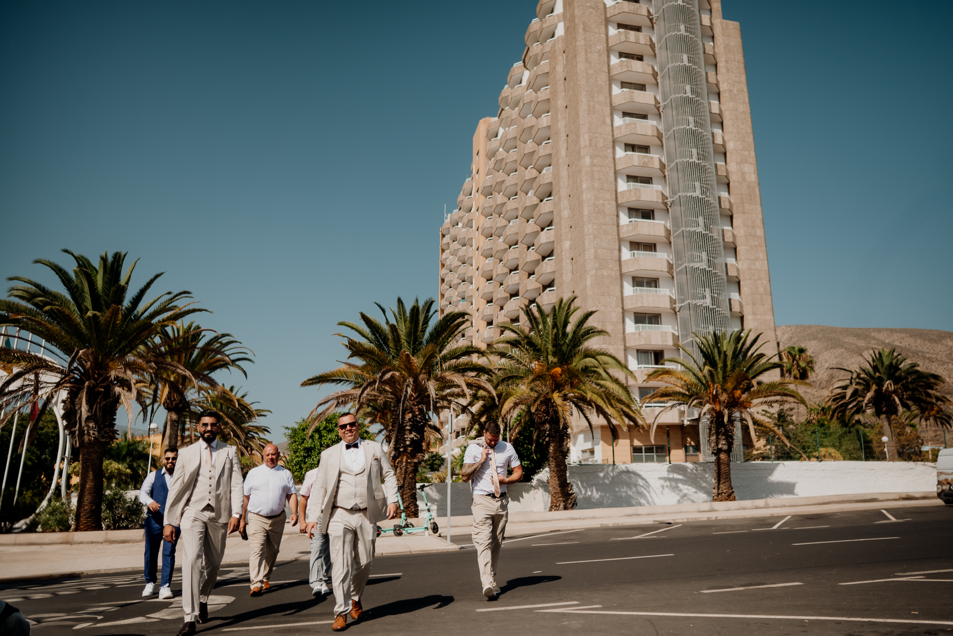 A group of people walking on a street next to a tall building