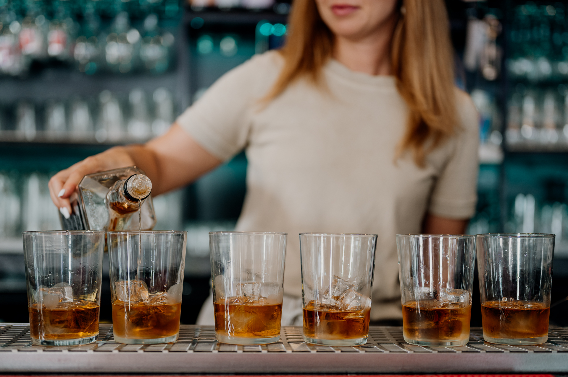 A woman pouring beer into glasses