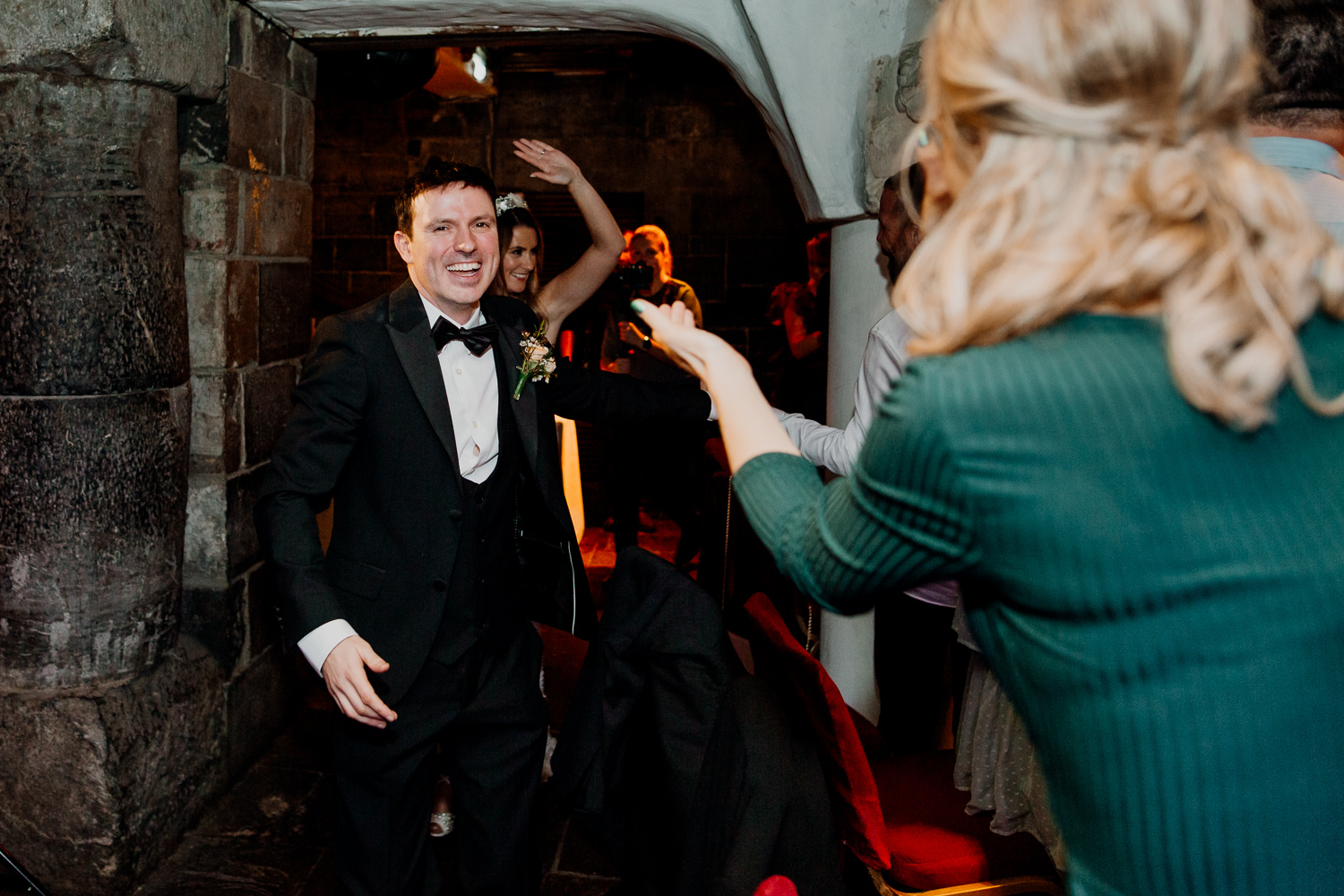 A man in a suit and a woman in a dress with a bird on his head