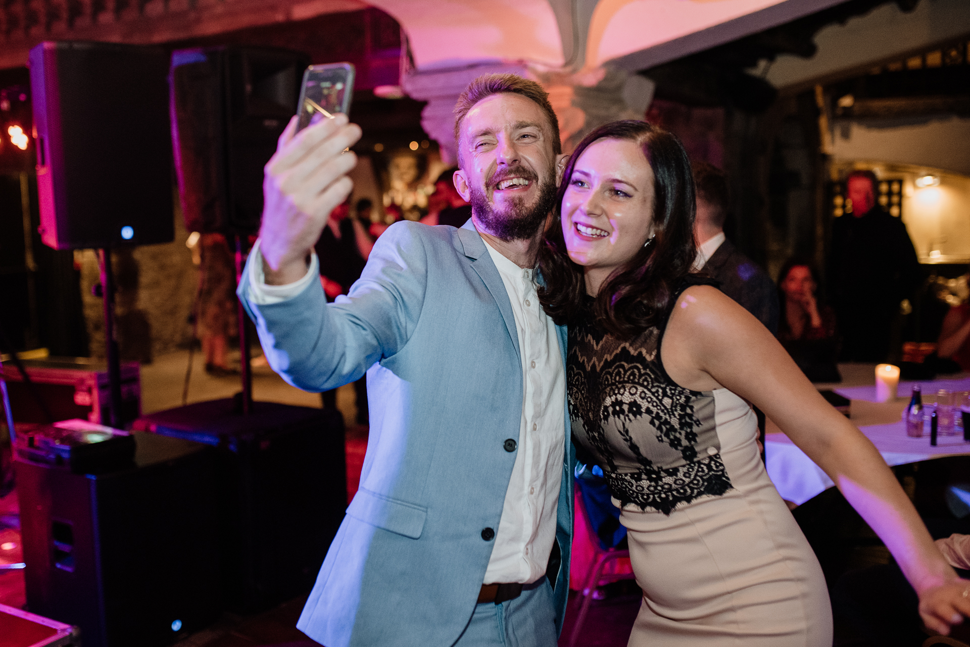 A man and woman taking a selfie in a bar