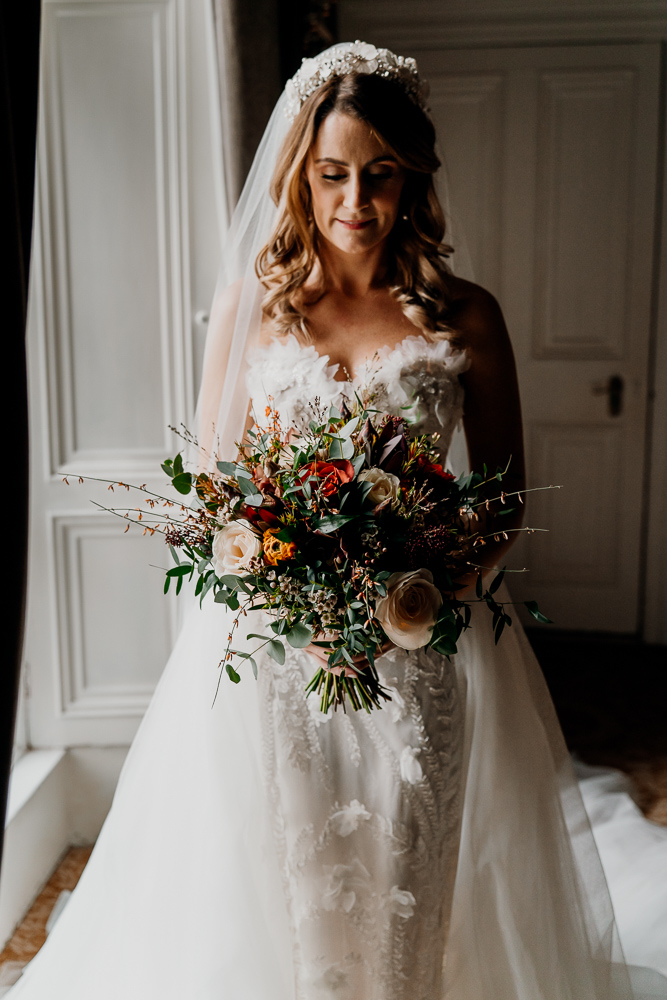 A woman in a white dress holding a bouquet of flowers