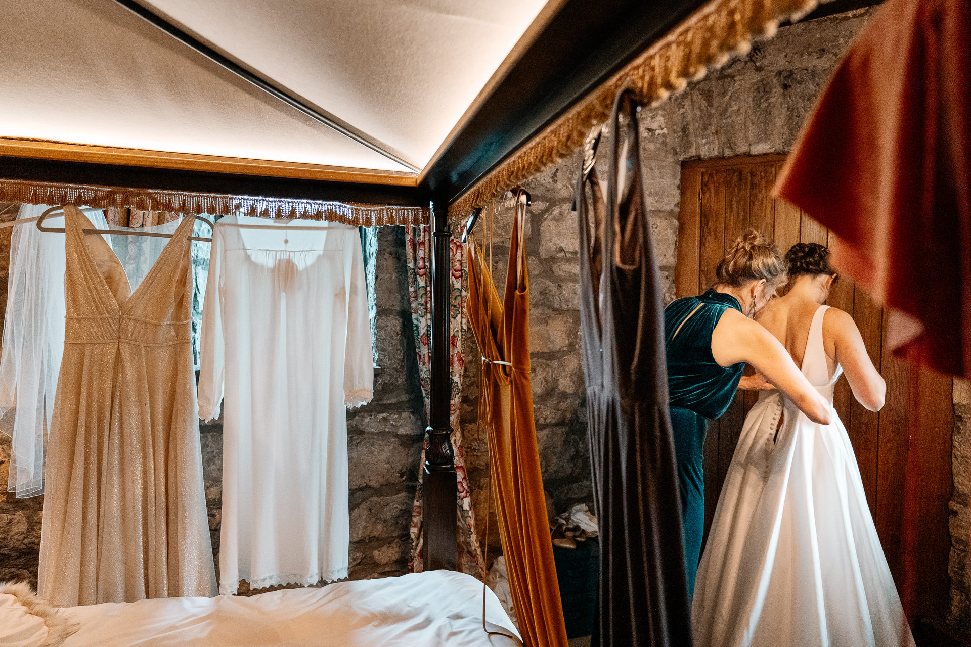 A bride and groom kissing in a room with curtains