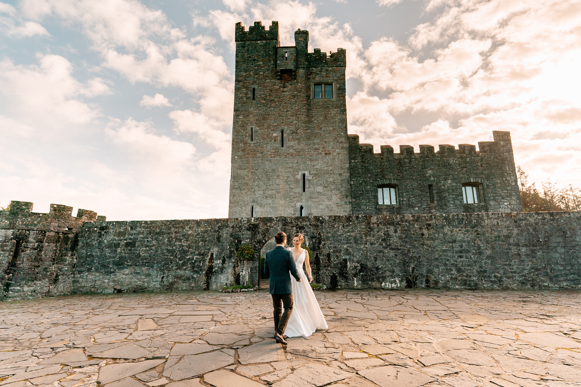 A man and woman in front of a castle