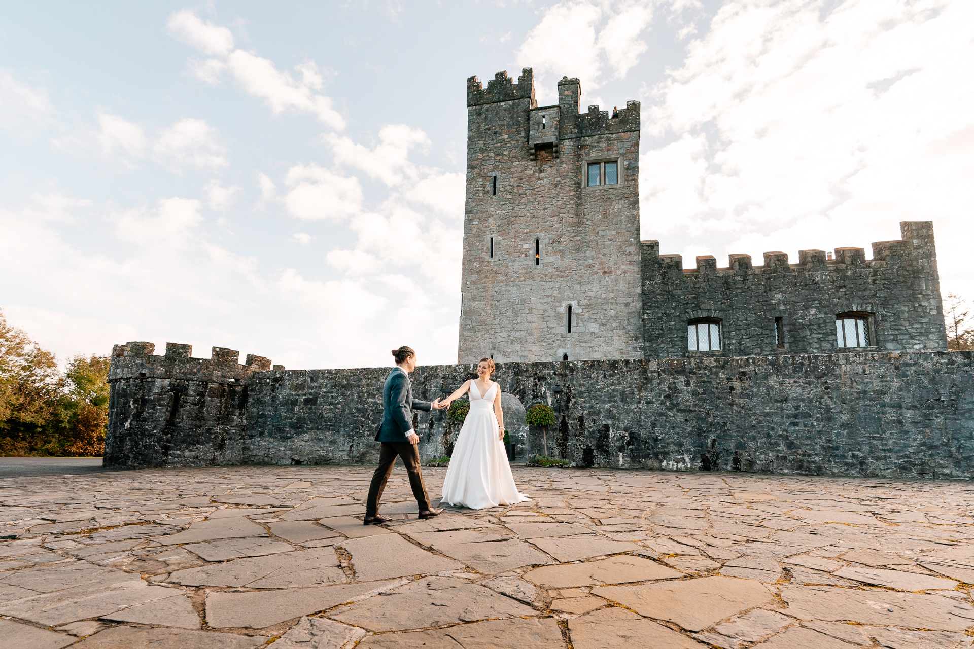 A man and woman in front of a castle