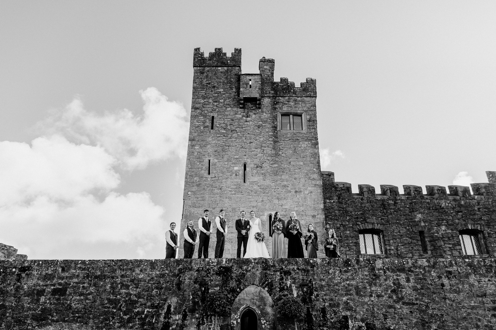 A group of people standing on a stone wall in front of a castle