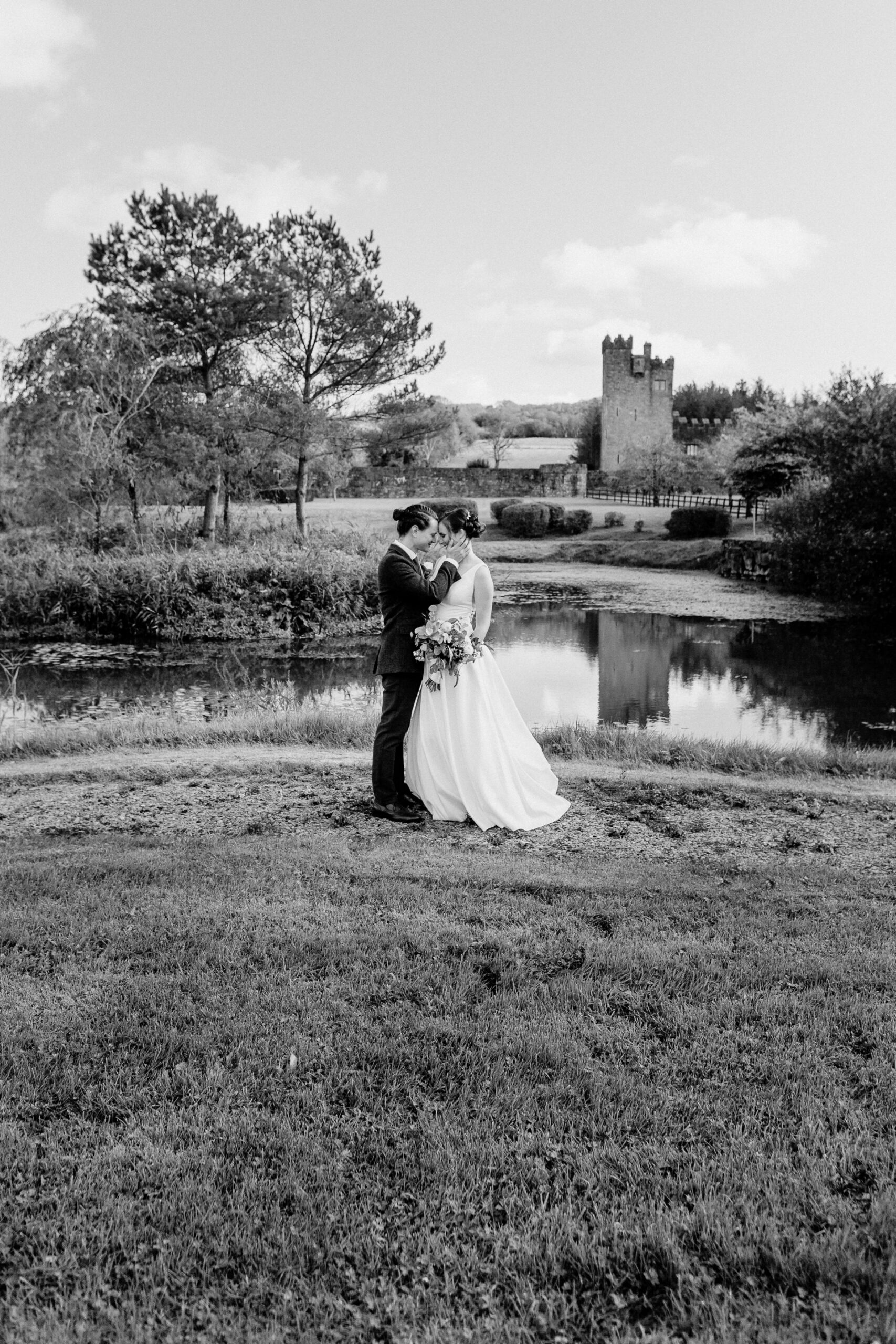 A man and woman kissing in front of a pond