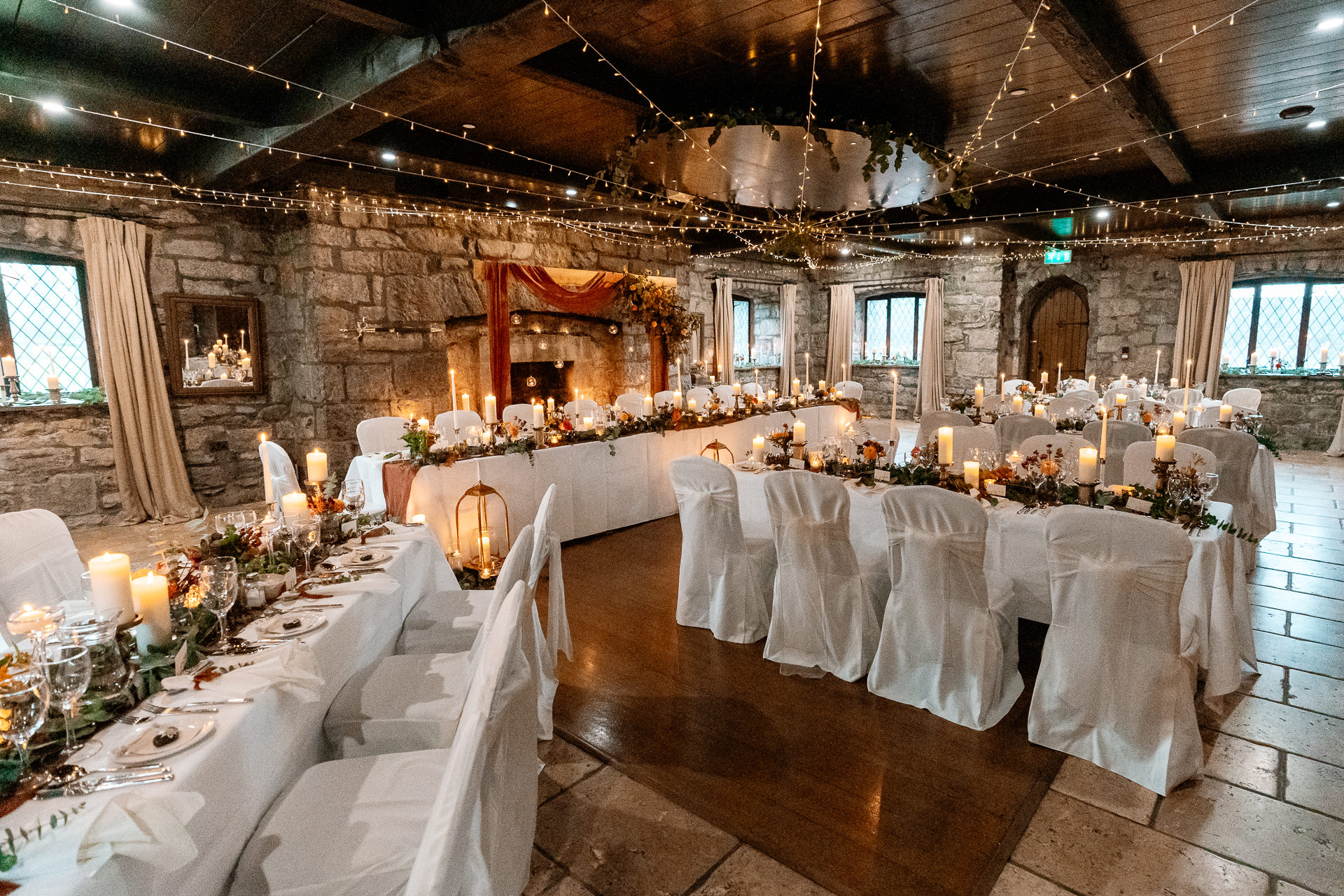 A room with tables and chairs with candles on them