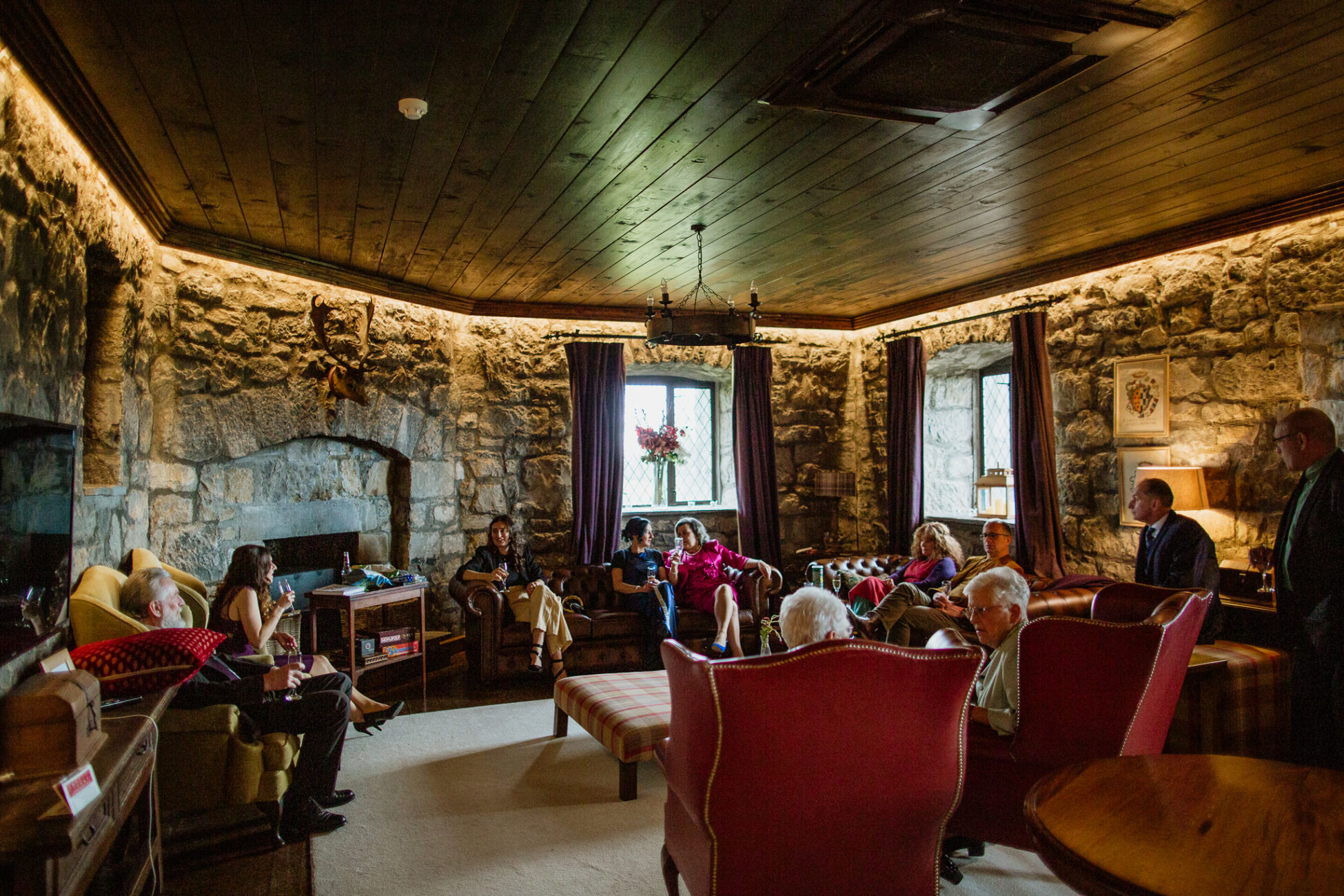 A group of people sitting in a room with a fireplace