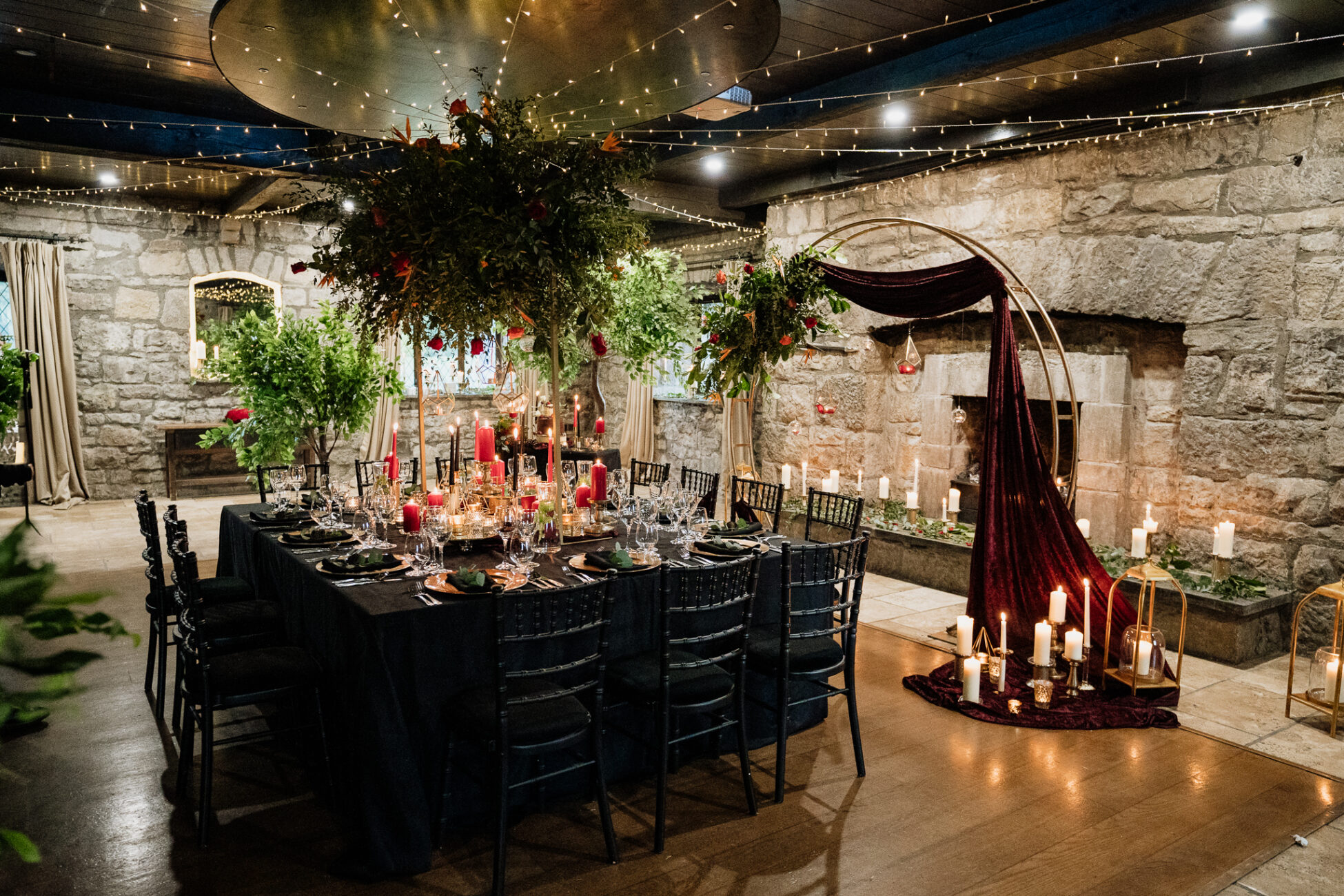 A dining room with a table and chairs and a tree with lights