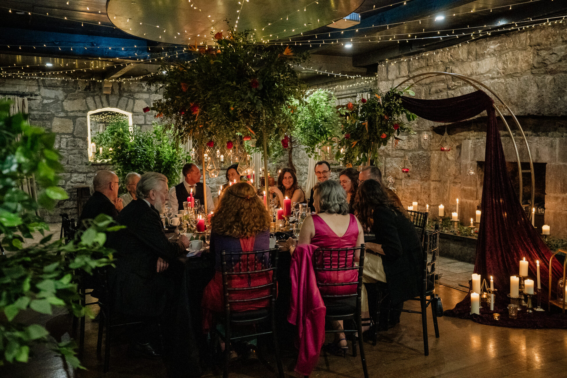 A group of people sitting at a table with candles