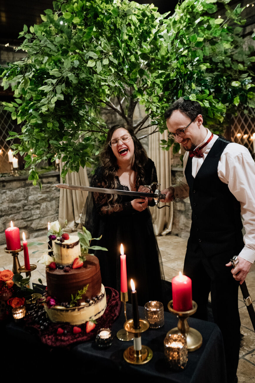 A man and woman standing next to a cake with candles