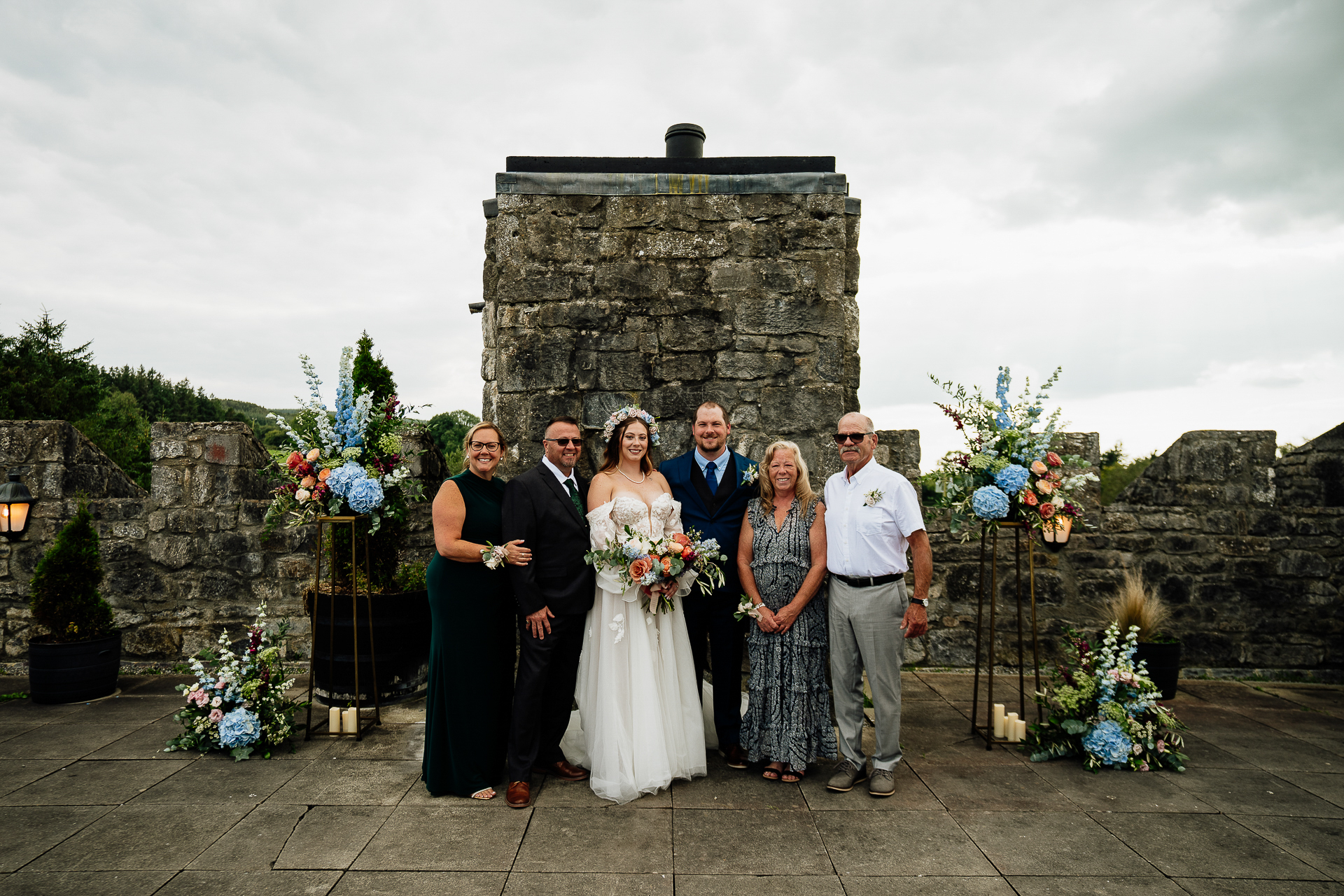 A group of people posing for a photo in front of a stone building