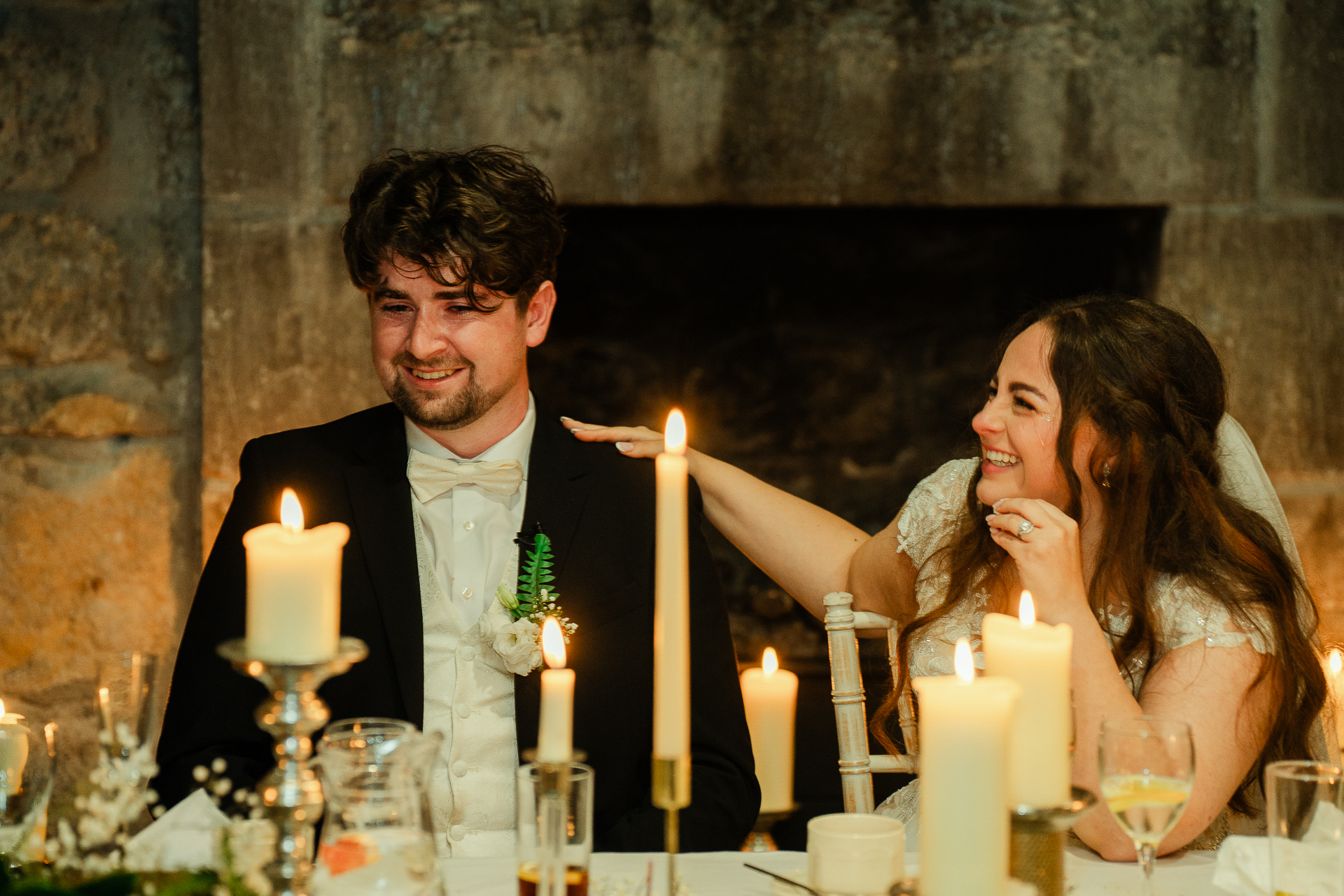 A man and woman sitting at a table with candles