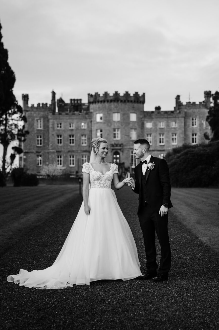 A man and woman posing for a picture in front of a building