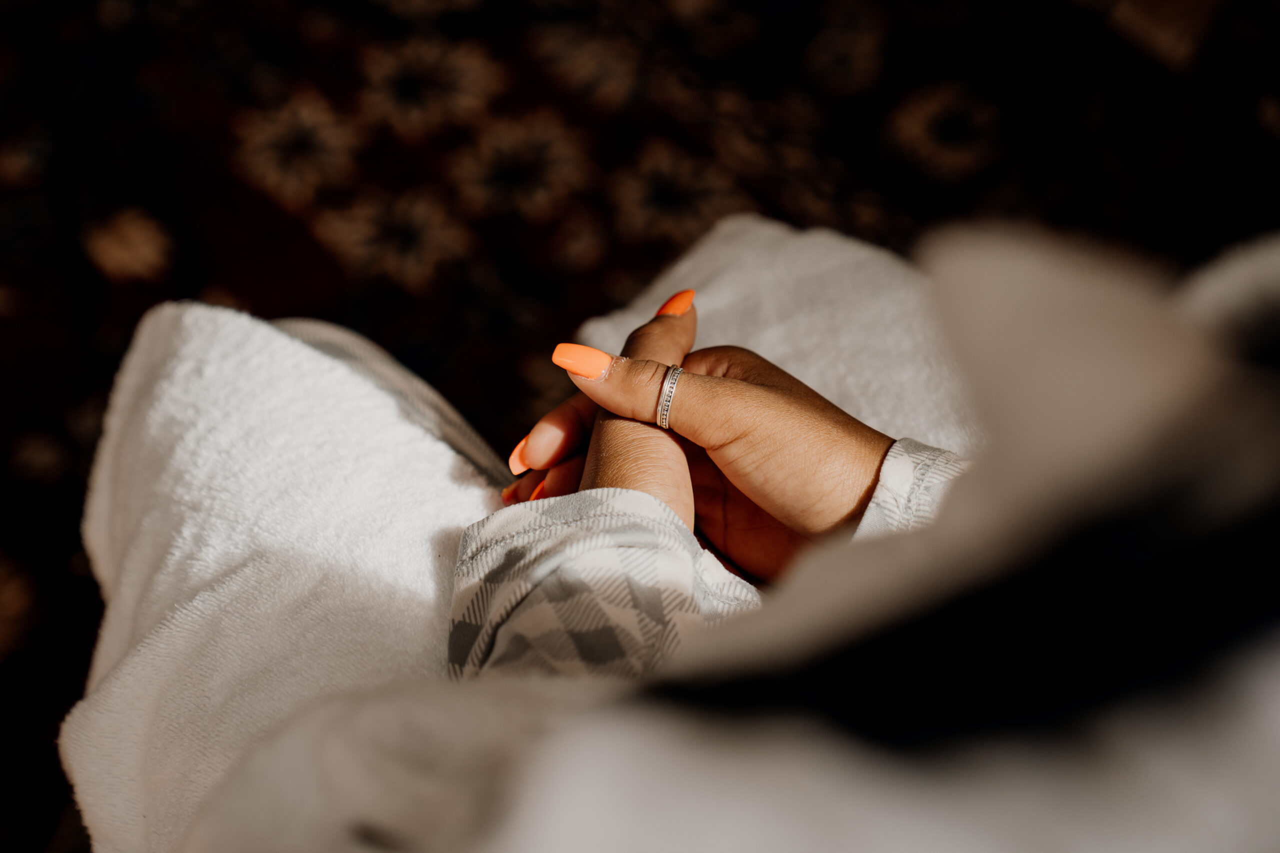 A person's hand holding a white cloth over a white surface