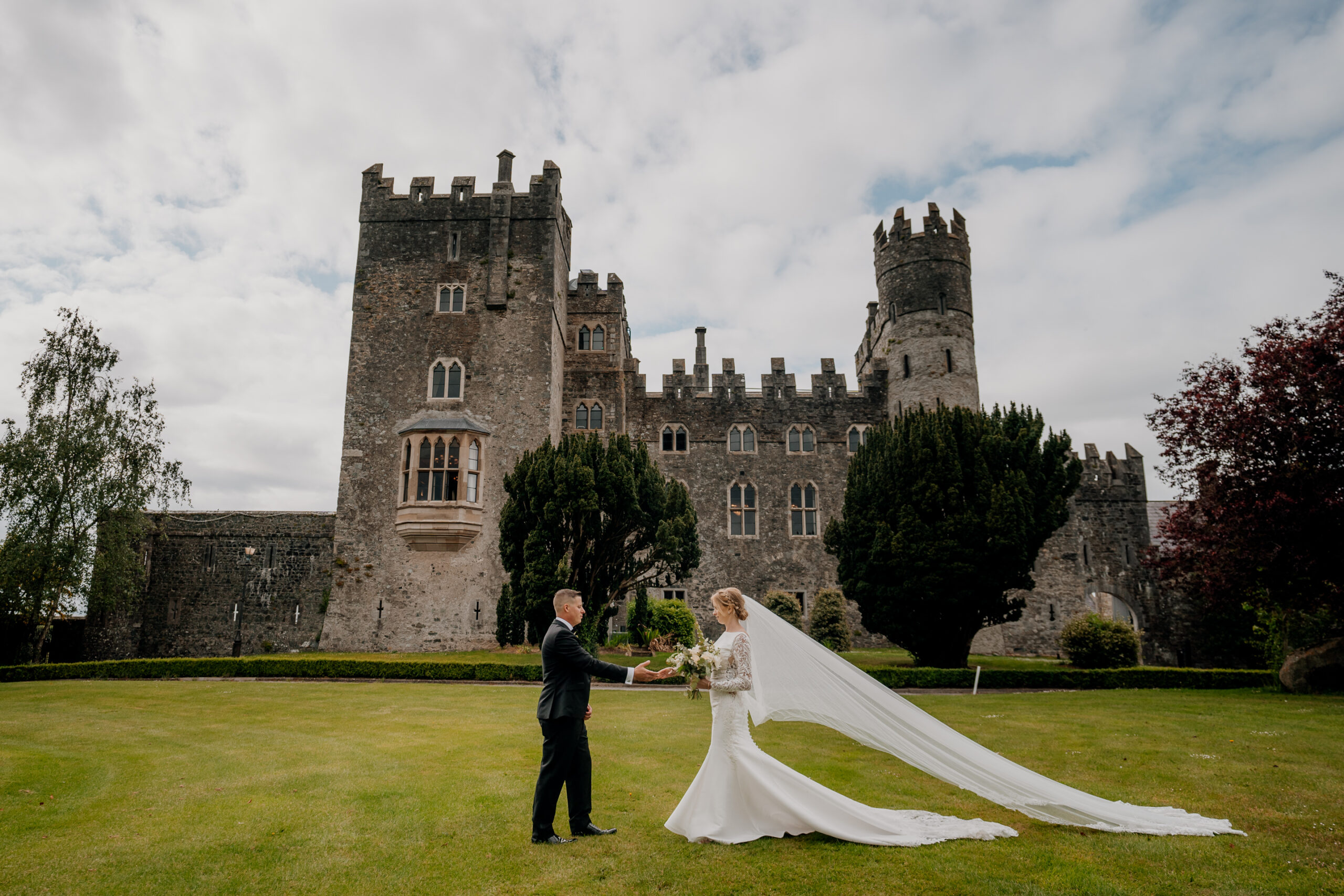 A man and woman in front of a castle