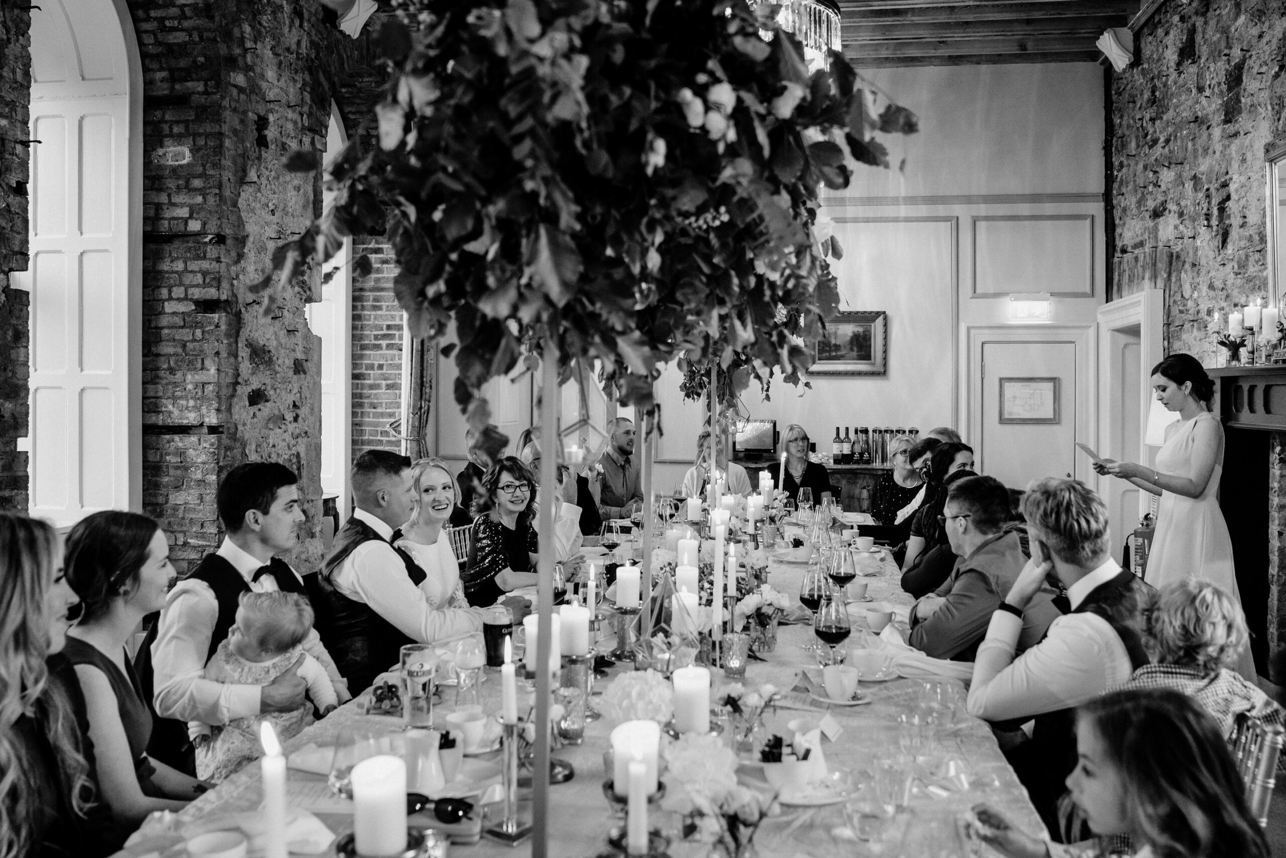 A group of people sitting around a table with candles