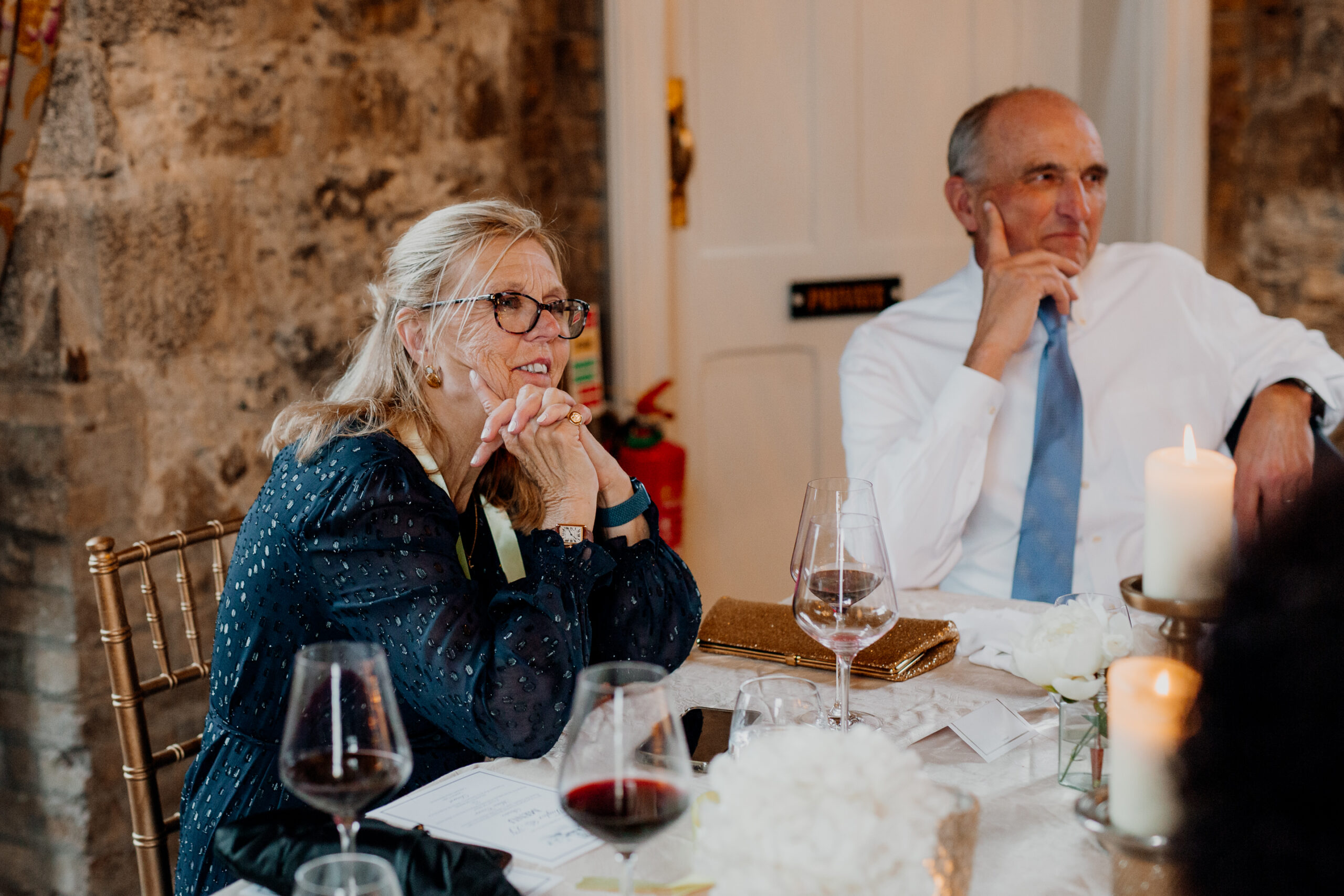 A man and a woman sitting at a table with wine glasses