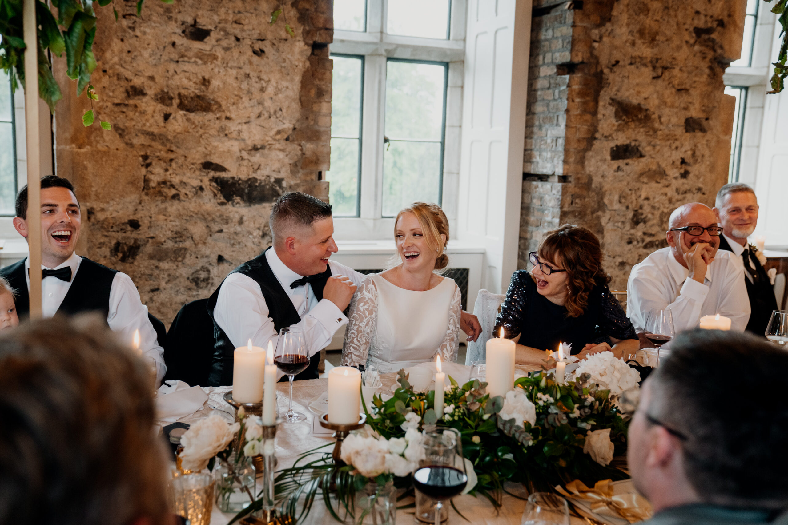 A group of people sitting around a table with candles